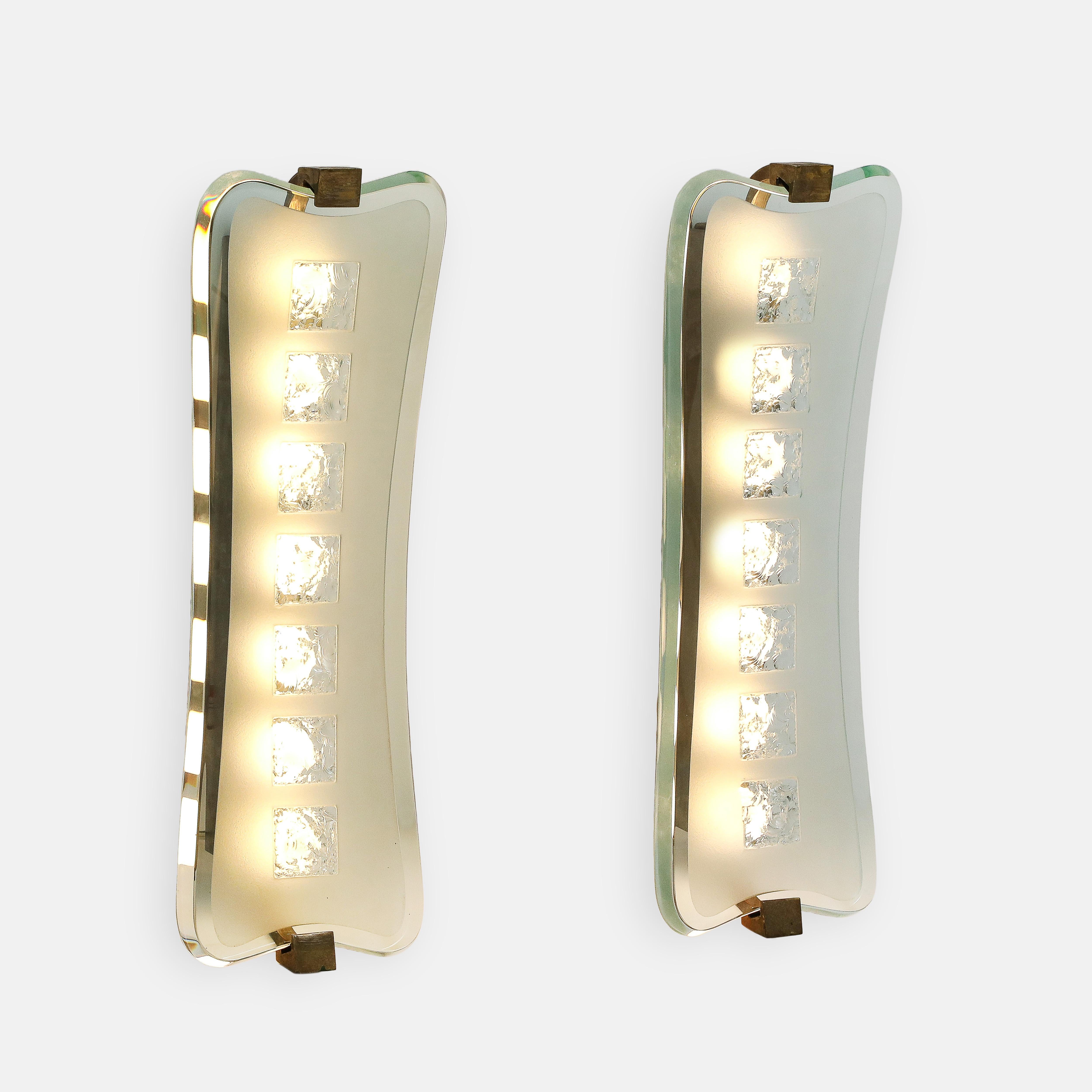 Max Ingrand for Fontana Arte rare large pair of sconces model 1568 with thick large curved crystal glass plates consisting of polished outer frame and inner satin-finished glass with central hand chiseled squares and beveled edges, brass mounts, and