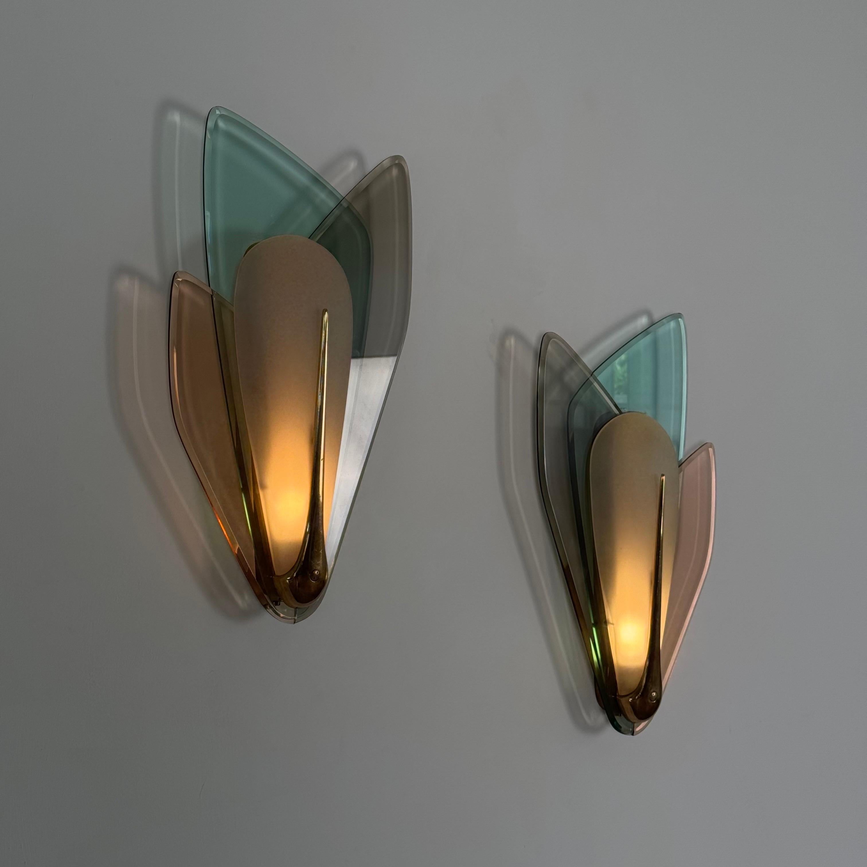 Diseñado en 1955 por Max Ingrand para Fontana Arte, este raro par de grandes apliques de pared ejemplifica la elegancia poética y la maestría técnica que definieron la iluminación italiana de posguerra. Cada aplique presenta tres hojas de cristal