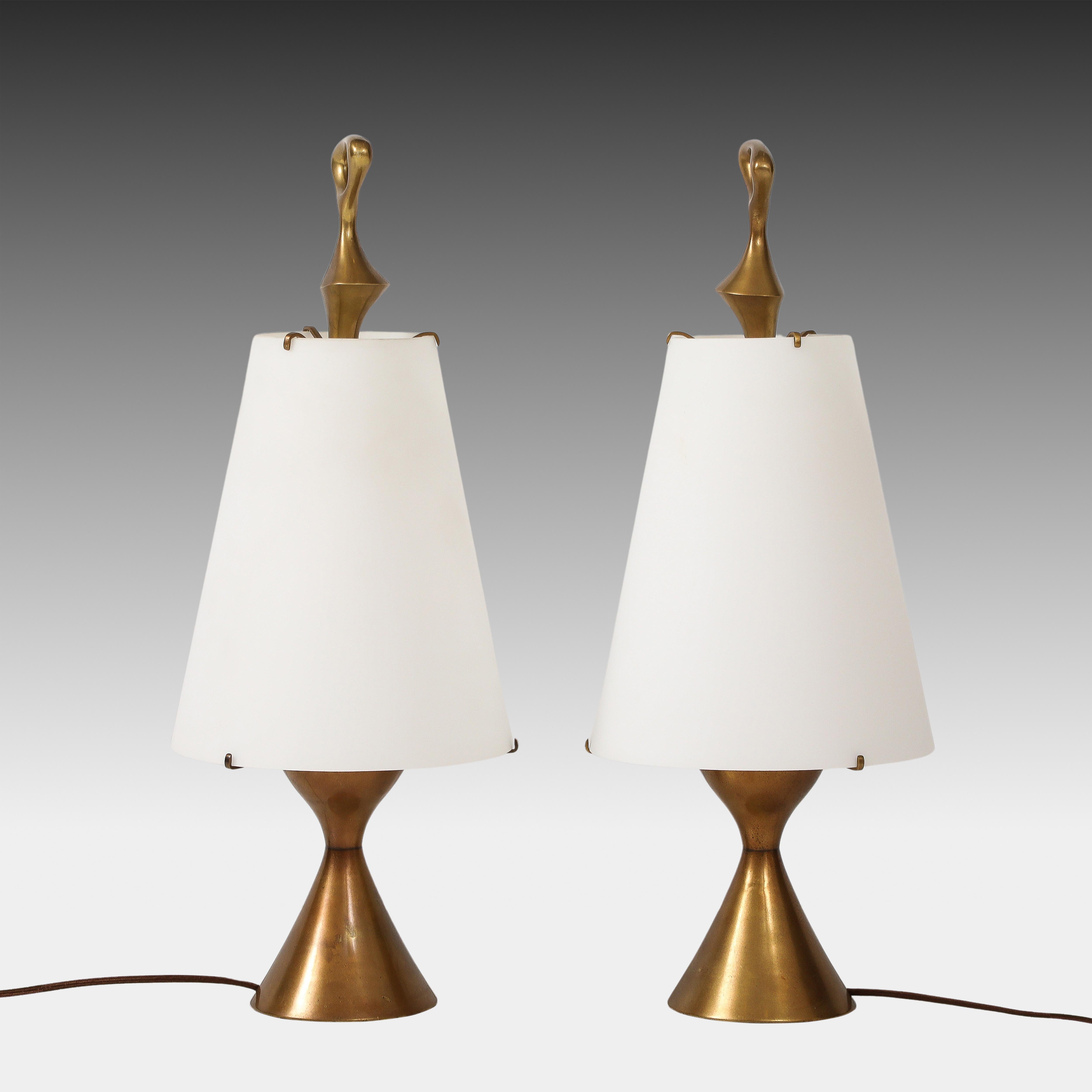 Rara pareja de exquisitas lámparas de sobremesa Max Ingrand para Fontana Arte con escultural base de latón lacado en forma de reloj de arena y abstracto remate con pantalla cónica de vidrio esmerilado montada. El contraste entre el suave blanco mate