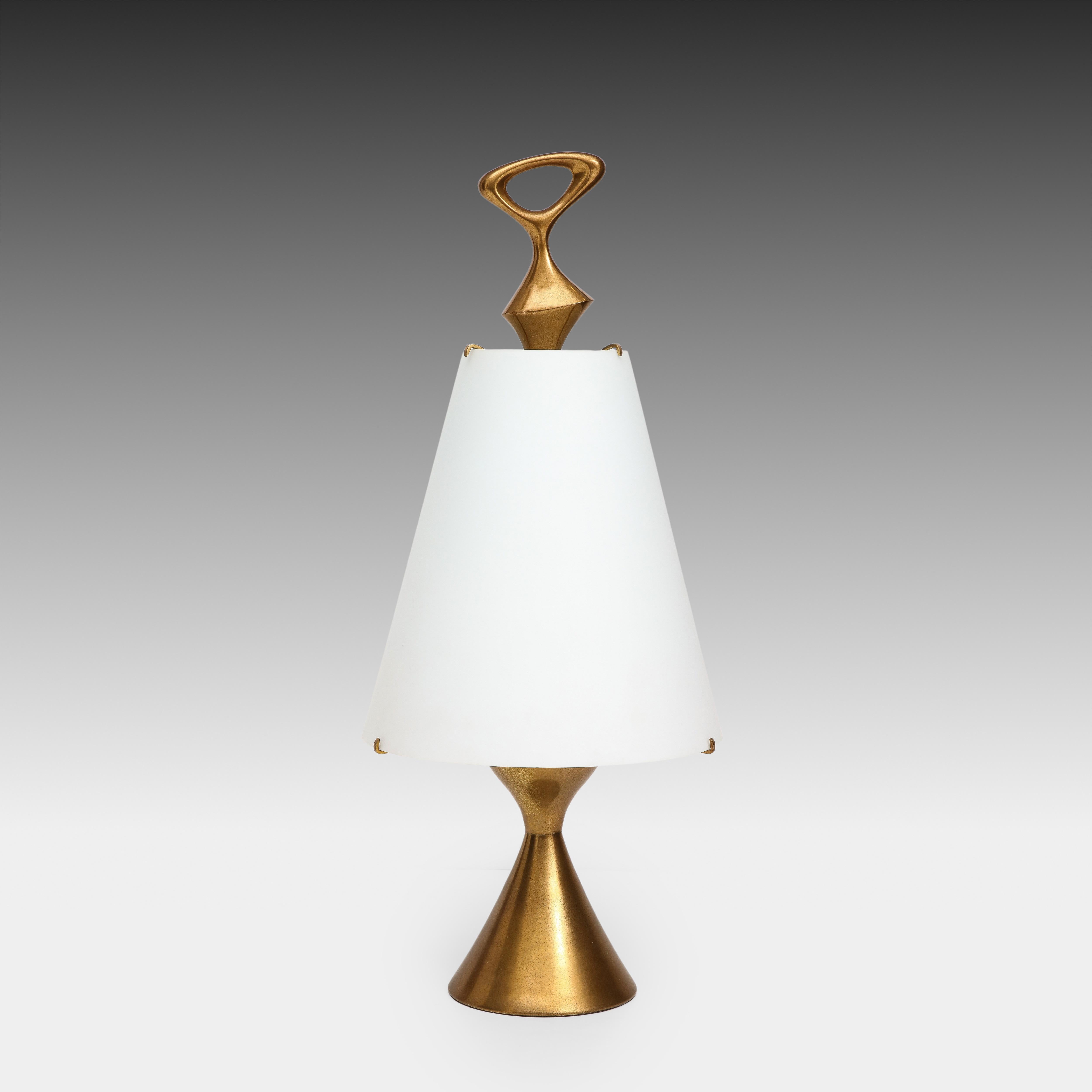 Max Ingrand for Fontana Arte rare exquisite table lamp with sculptural hourglass shaped lacquered gilt brass base and abstract finial with mounted conical opaline glass shade. The contrast between the soft matte white of the opaline glass and the 