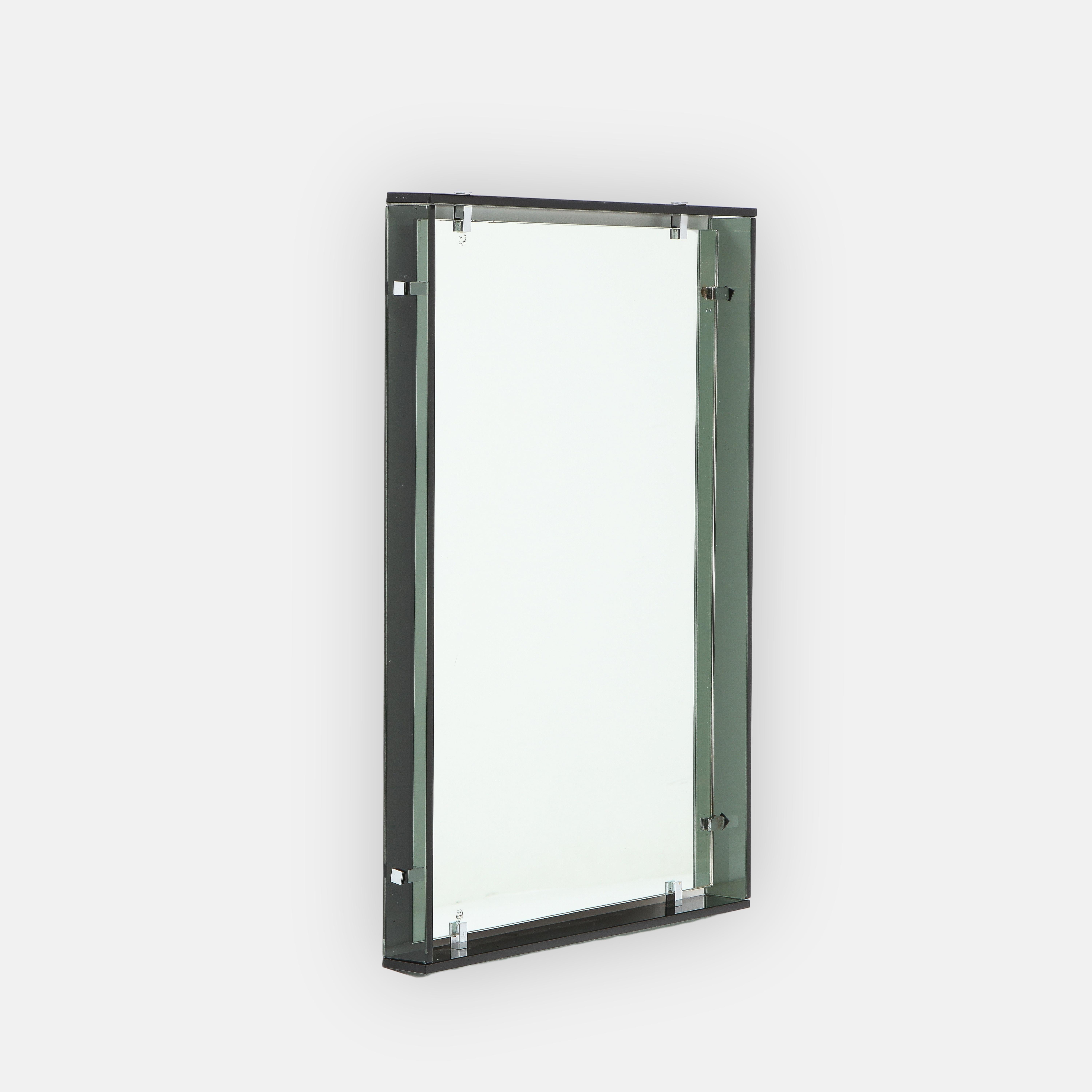 Max Ingrand for Fontana Arte rectangular mirror model 2014 consisting of thick dark gray/green colored strips of crystal glass surrounding original mirrored glass with nickel-plated brass clip supports, Italy, 1960s. This modernist and chic design