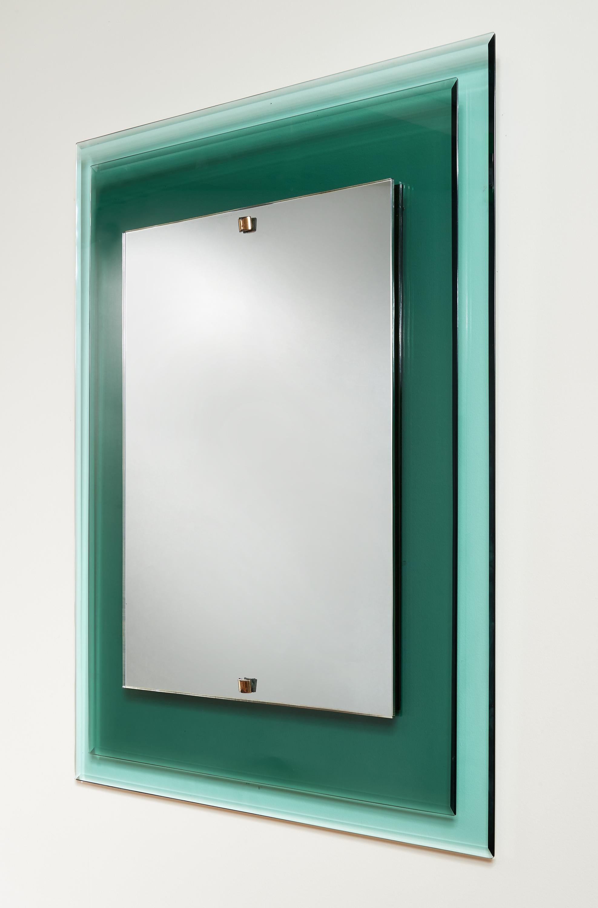 Max Ingrand (1908-1969)

A stunning rectangular mirror by Max Ingrand for Fontana Arte, with a striking staggered double frame comprised of three concentric rectangles in beveled emerald green and aqua colored glass, surrounding a clear mirror. With