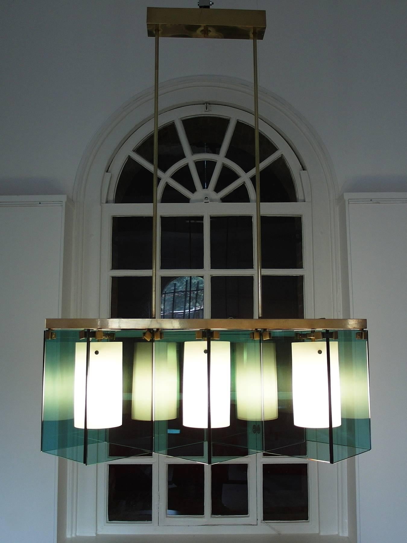 A rare chandelier designed by Max Ingrand for Fontana Arte, Italy, 1964. Fontana Arte model number 2128.
This stunning chandelier is composed of two rectangular and eight square translucent green (verde nilo) crystal glass panels and three satin