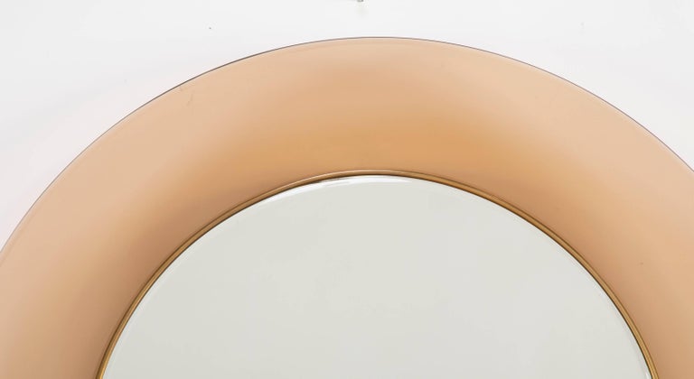 Model 1699 round mirror with peach glass molded frame, circa 1960.