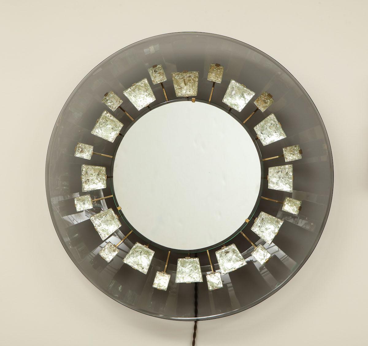 Rare Illuminated mirror by Max Ingrand. Model # 2044, featuring 24 chipped crystal chunks attached to articulating brass arms. Curved back-plate of smoked gray colored glass and center mirror concealing 3 candelabra sockets. This model dates to 1966