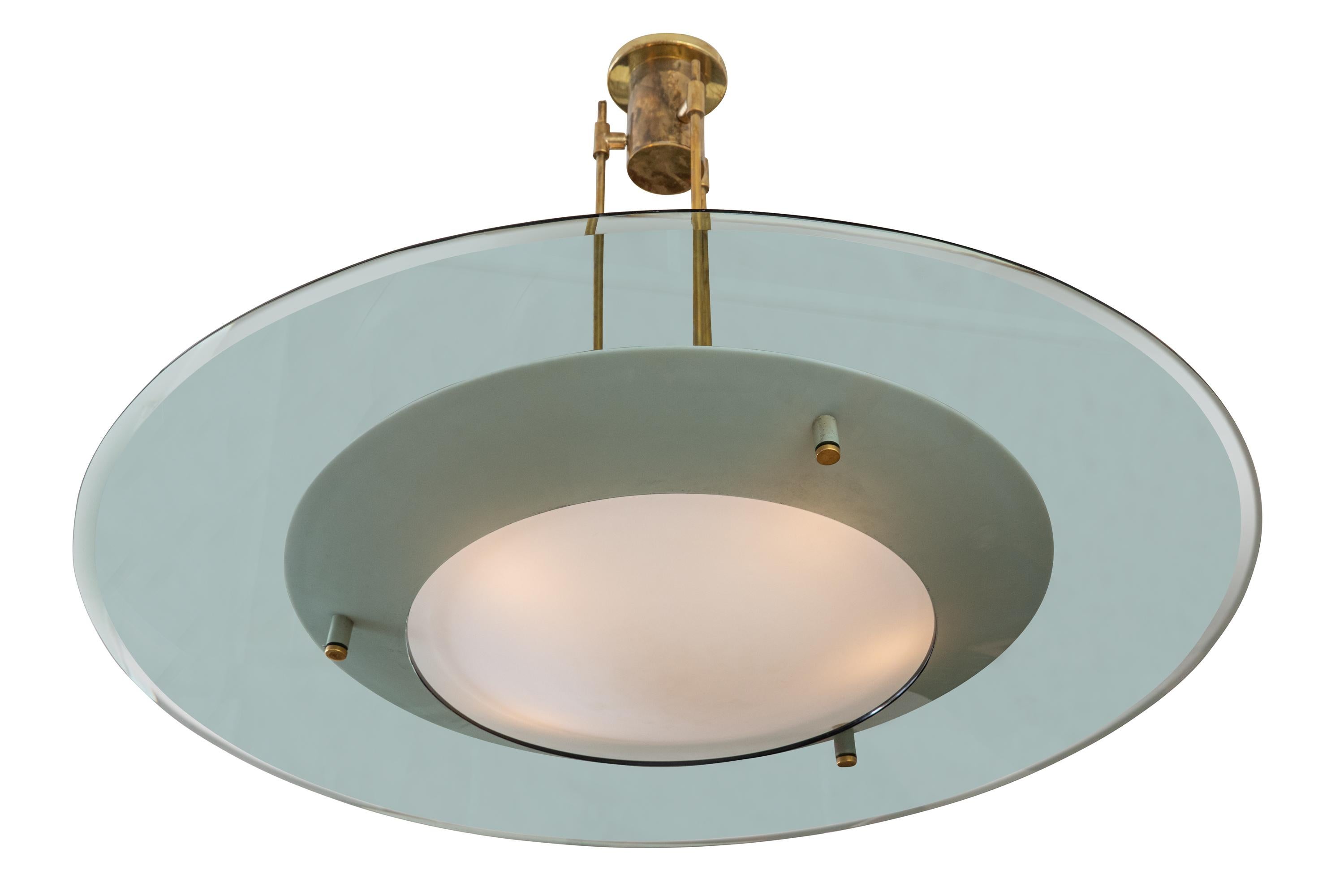Fontana Arte chandelier model 2097 designed by Max Ingrand. It features a gray concave beveled glass disc with a conical frosted glass shade in the center. The frame is solid brass.
