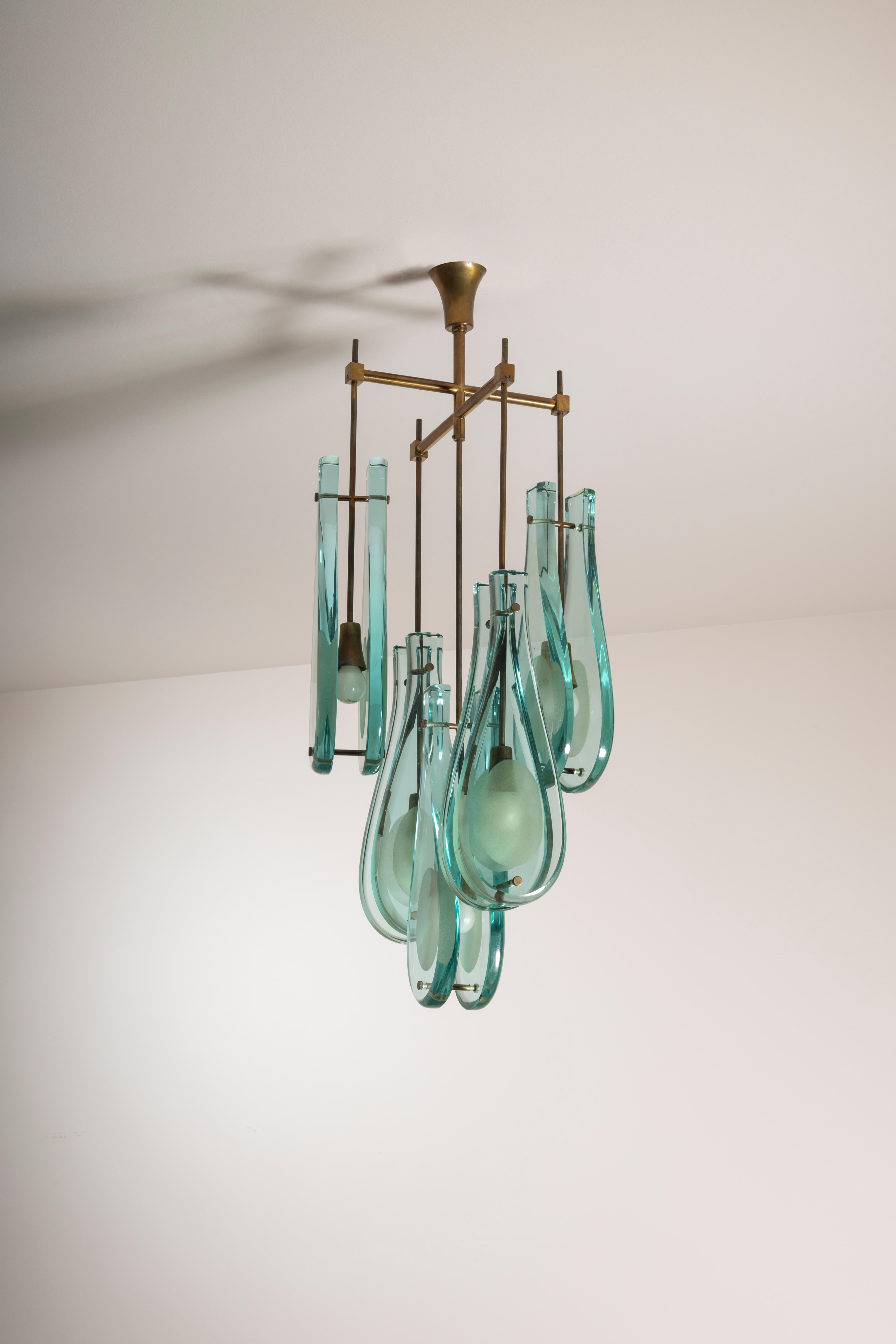 Brass and glass chandelier, designed by Max Ingrand, model 2338, manufactured by Fontana Arte during the 1960s.

This ceiling light boasts a commanding presence, characterized by its sophisticated and theatrical design. True to Max Ingrand's