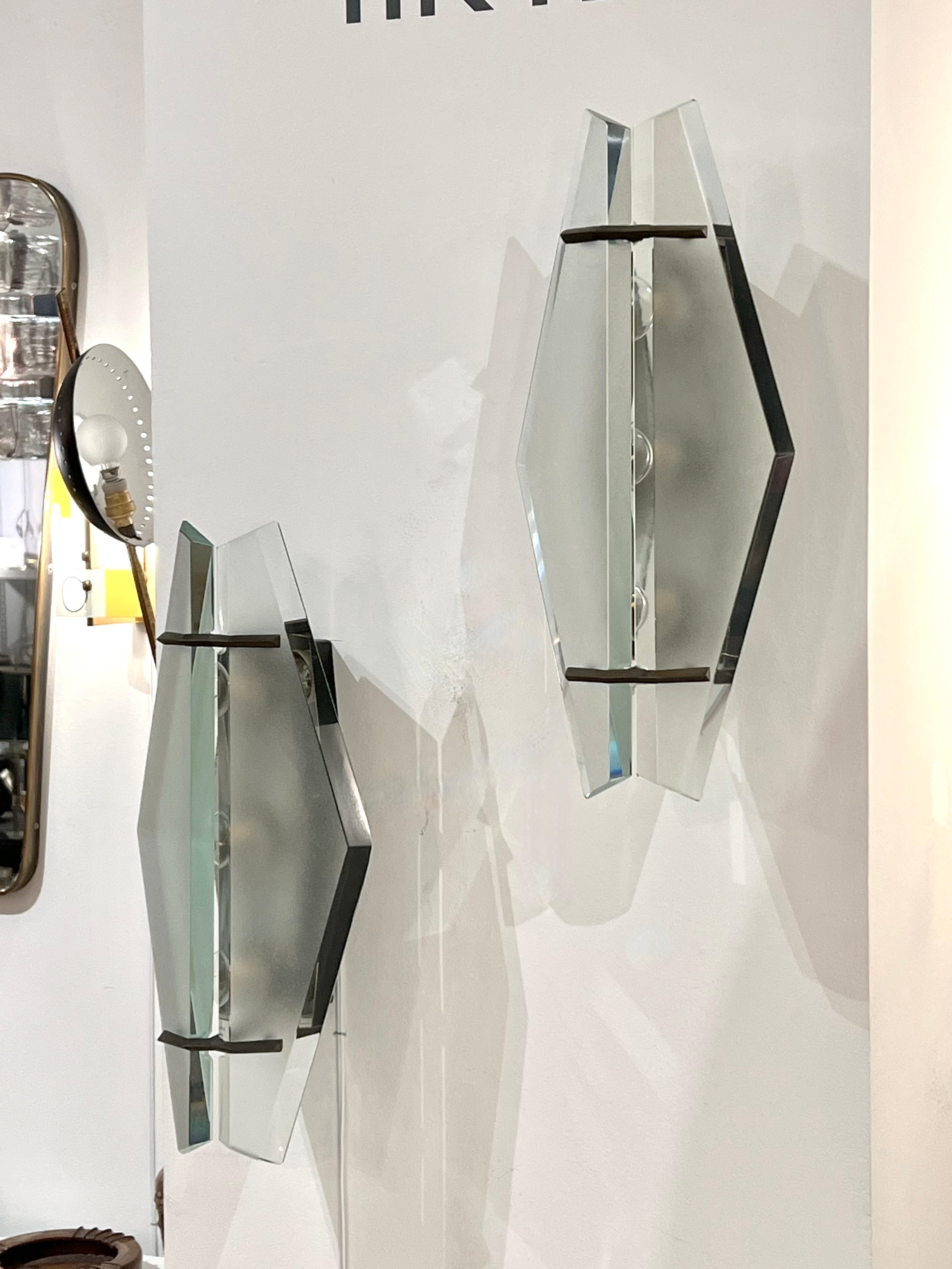 Pair of modernist sconces by Max Ingrand for Fontana Arte, with thick diamond shaped glass plates, beveled edge, held by metal mounts.