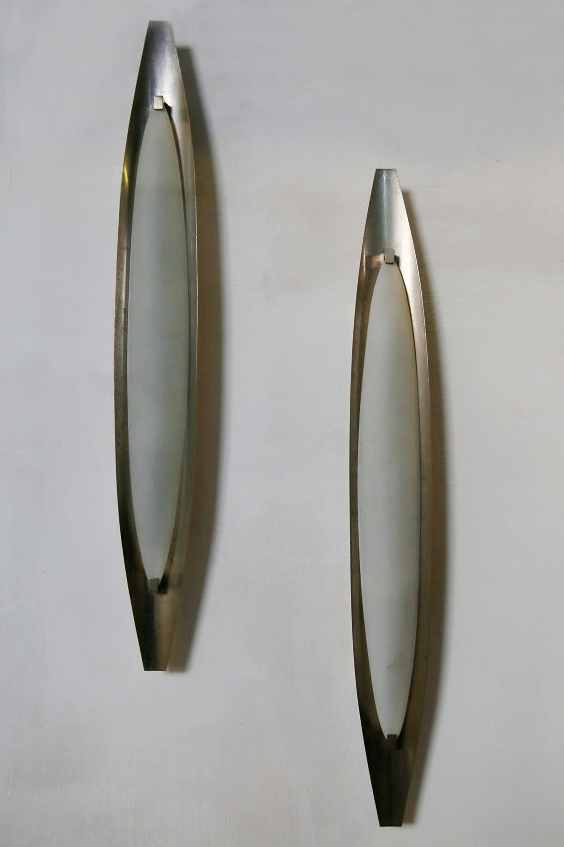 Pair of wall sconces designed by Max Ingrand for Fontana Arte in 1950s. The wall sconces are made of nickel-plated brass with an elongated oval shape. While the lampshade is made of opaline glass. 
The wall sconces are in very good condition very