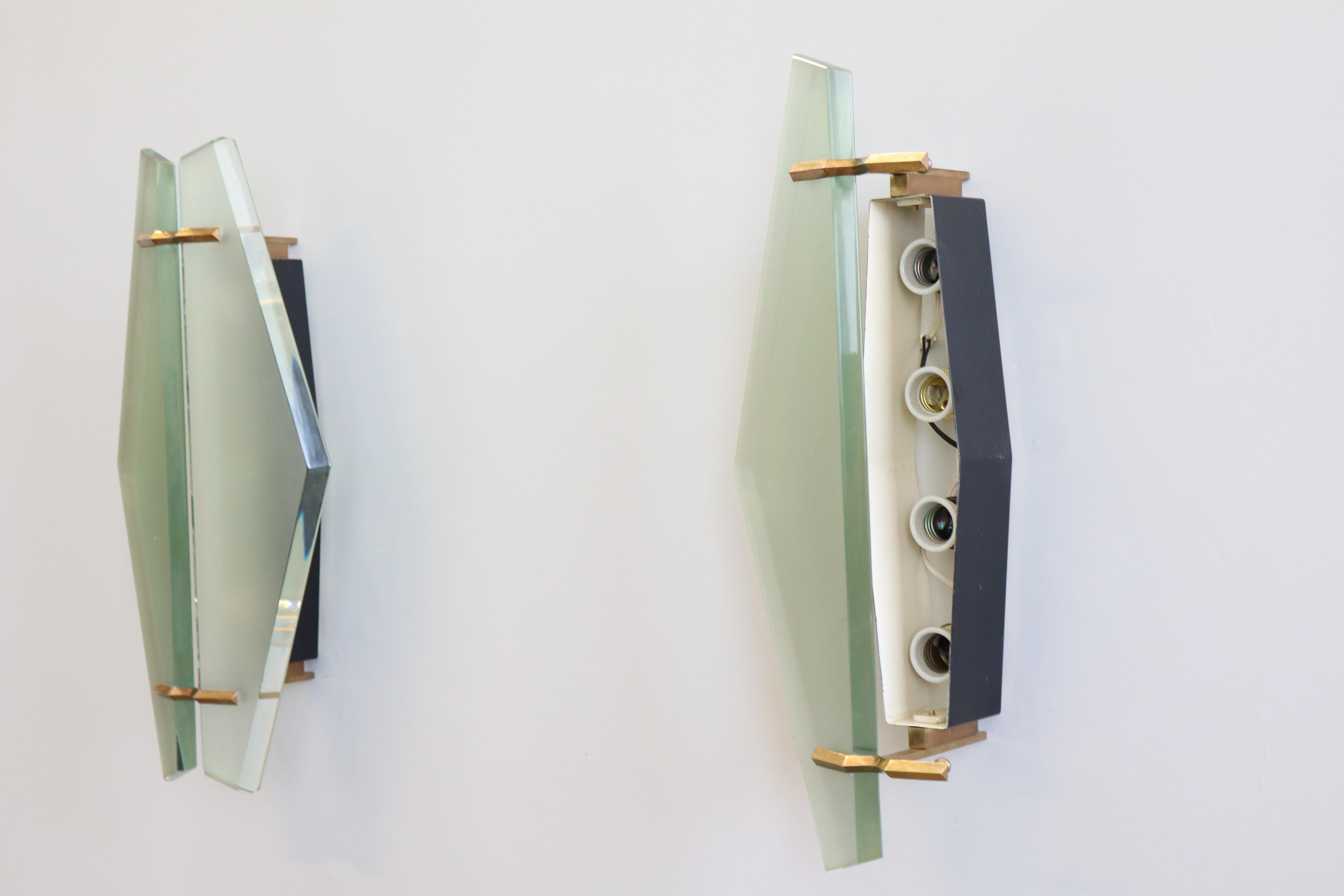 Grande coppia di applique da parete mod. 1943, realizzate con struttura in ottone e metallo e schermi in vetro satinato con profili molati, disegnate da Max Ingrand e prodotte da Fontana Arte, 1960 circa.  Completamente originale e in buone