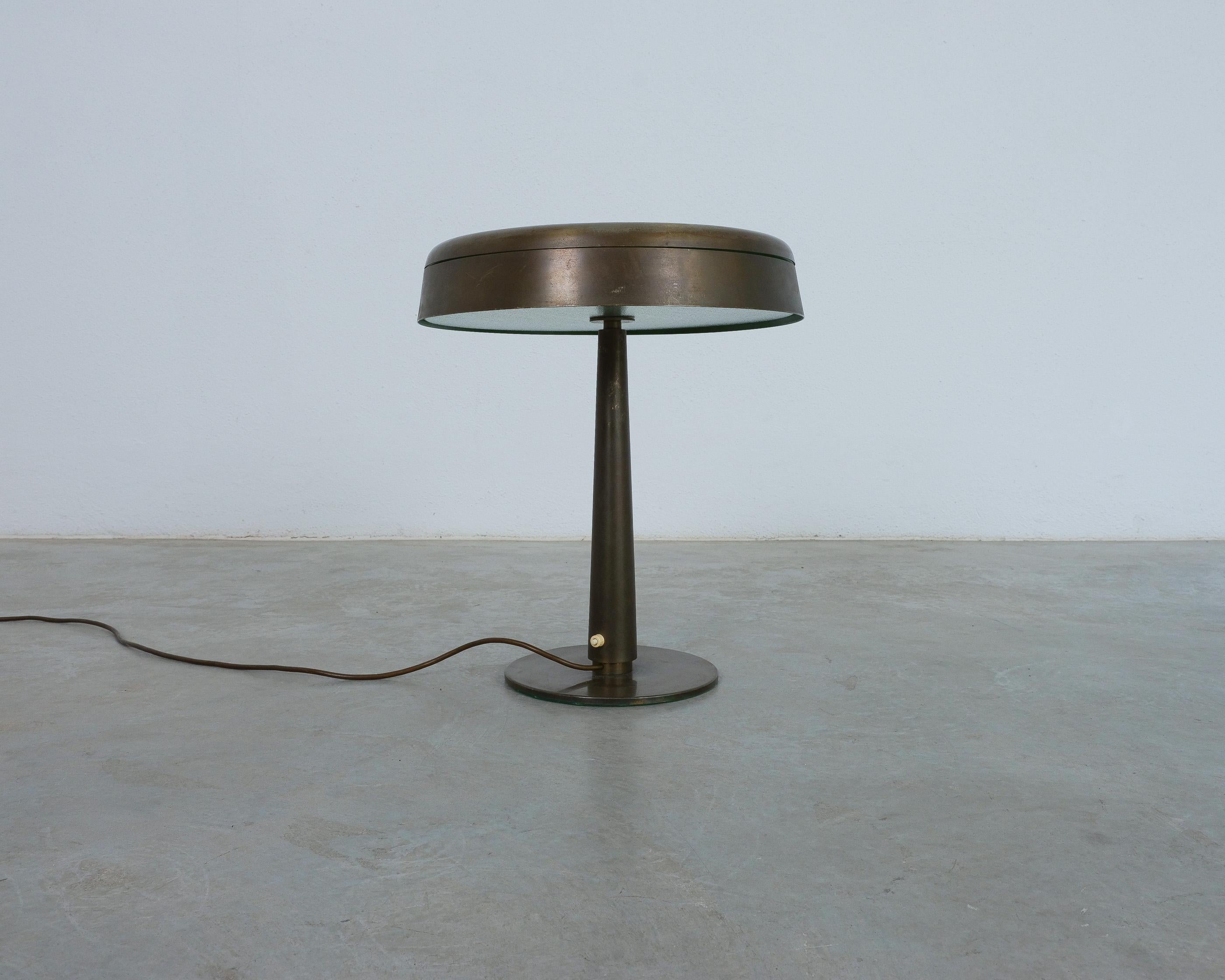 Una versión antigua del mod. 2278 para Fontana Arte, con pantalla interior verde y difusor de cristal plano. El latón ha adquirido una hermosa pátina con el paso de los años. Una lámpara de mesa pesada y elegante, con proporciones muy bien elegidas
