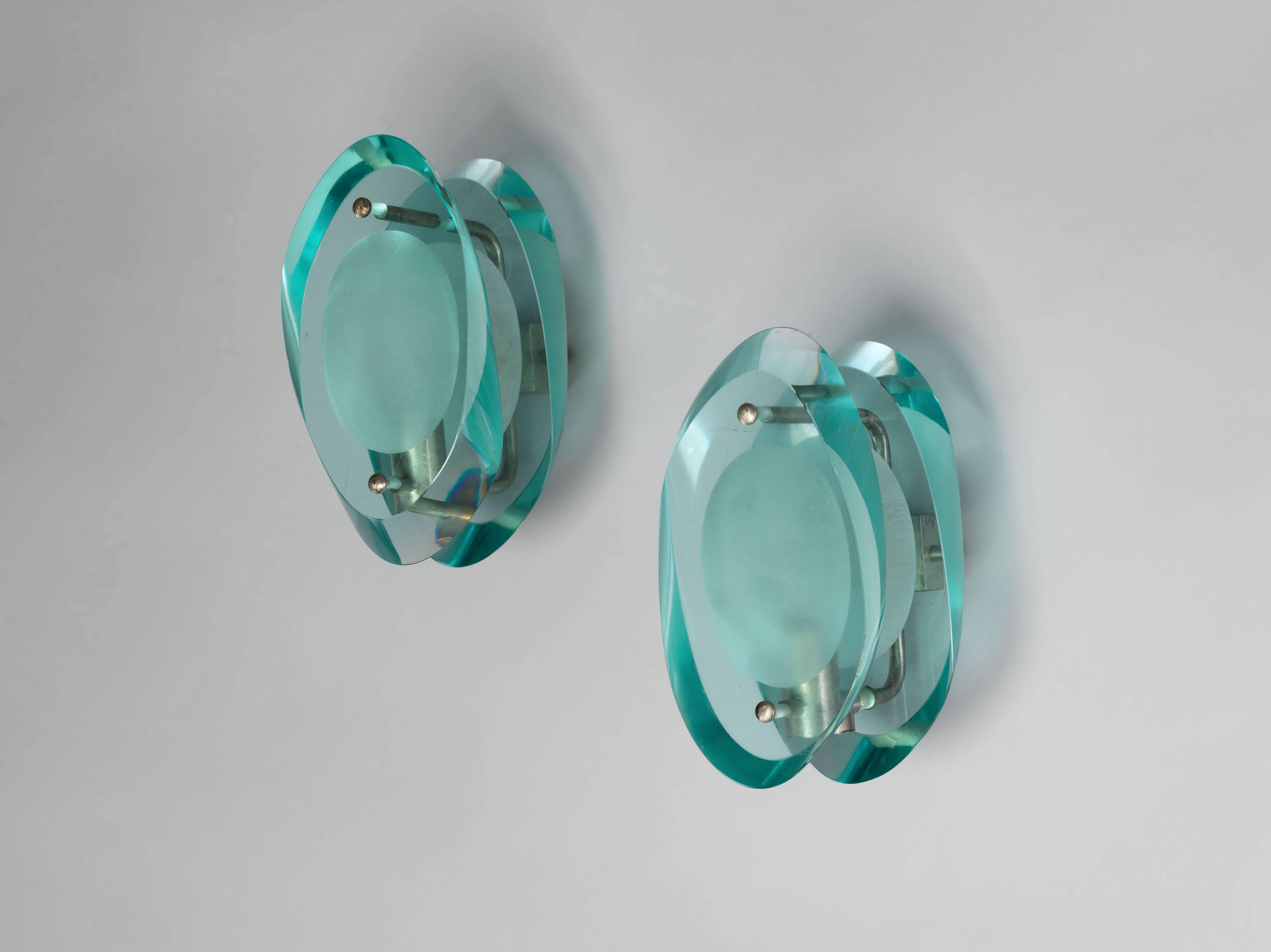 A pair of wall lamps/wall sconces, mod. 2093, by French designer Max Ingrand for Italian producer Fontana Arte. Nickel-plated brass and organically shaped, partially frosted light blue crystal glass.    Model documented in the original Fontana Arte