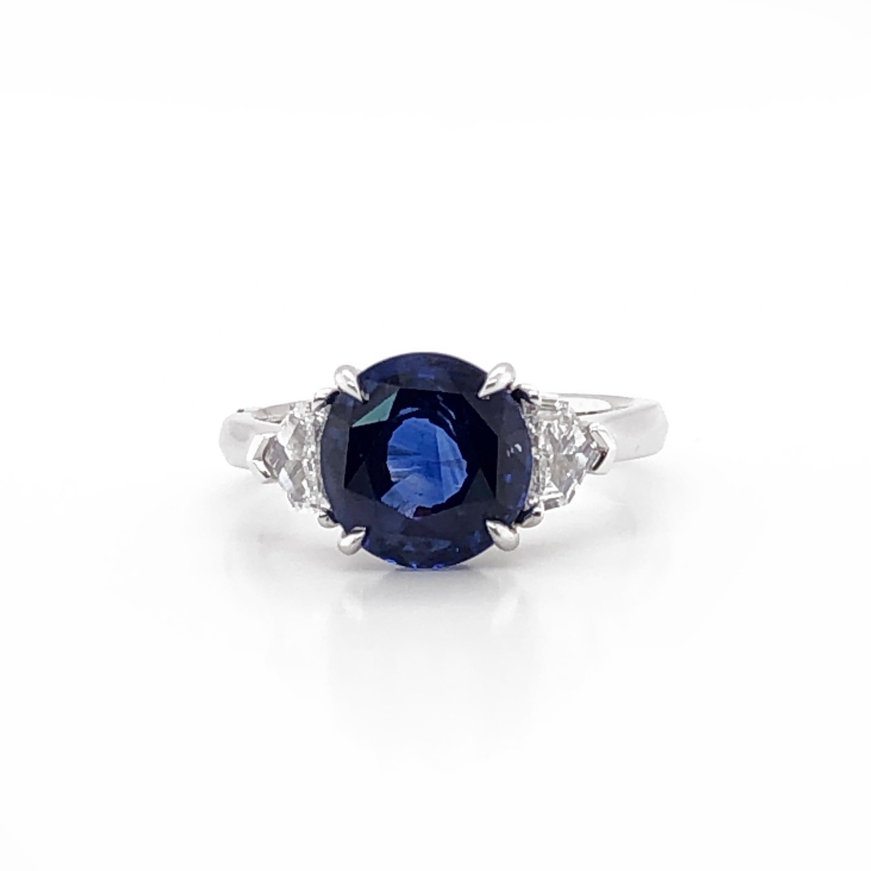 This elegant gemstone ring is crowned with a rich deep blue oval Ceylon sapphire 3.60 ct, accented at the sides with shield cut white diamonds 0.36 ct total. The white diamonds are natural in G-H Color Clarity VS.  Ring is platinum 950 metal. 