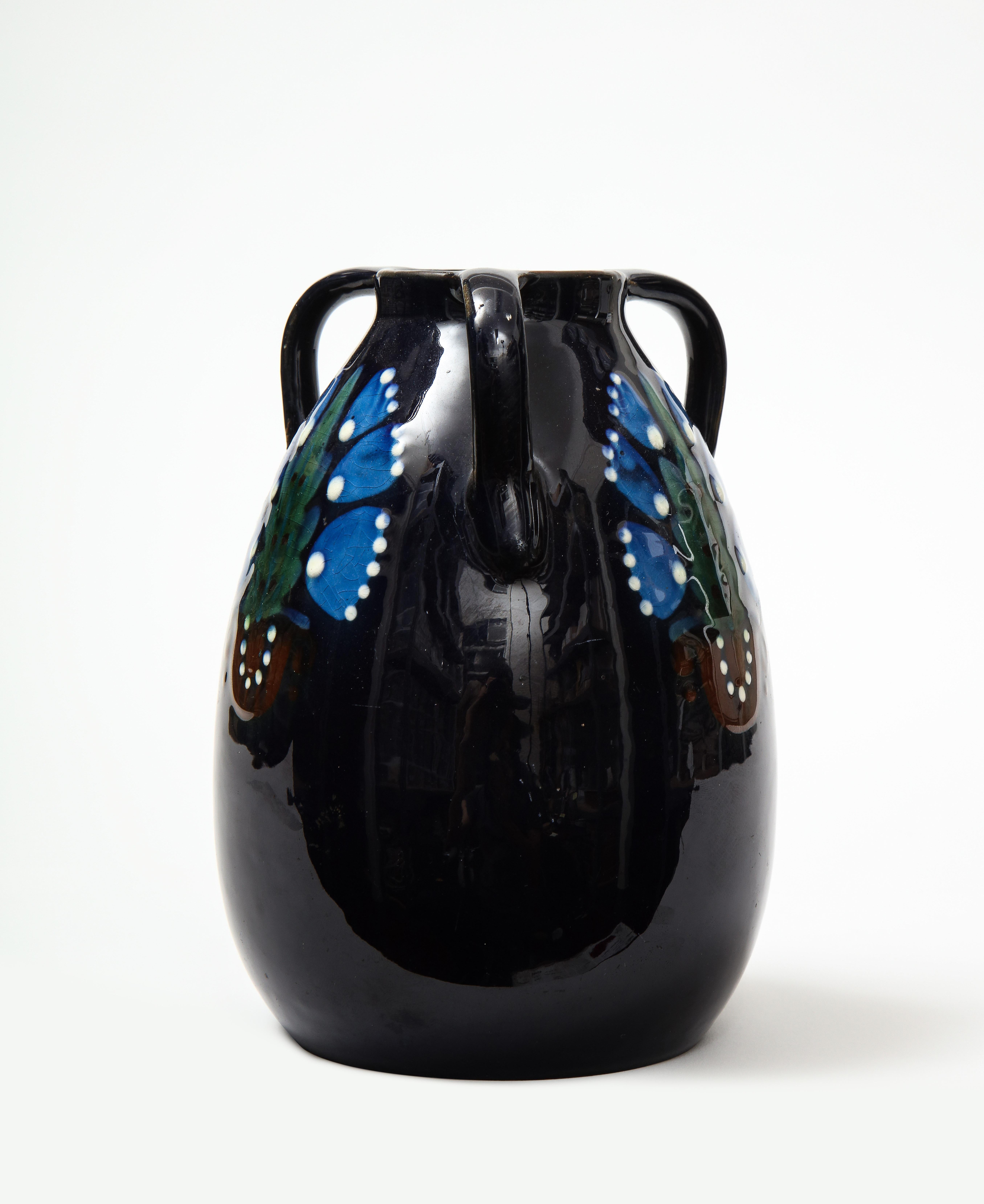 Ceramic vase by acclaimed architect and artist Max Laeuger, Germany, c. 1920s. 

This charming vase consists of a delightful, hand-painted floral motif typical of the Art Nouveau period set against a dark blue backdrop as well as three individual