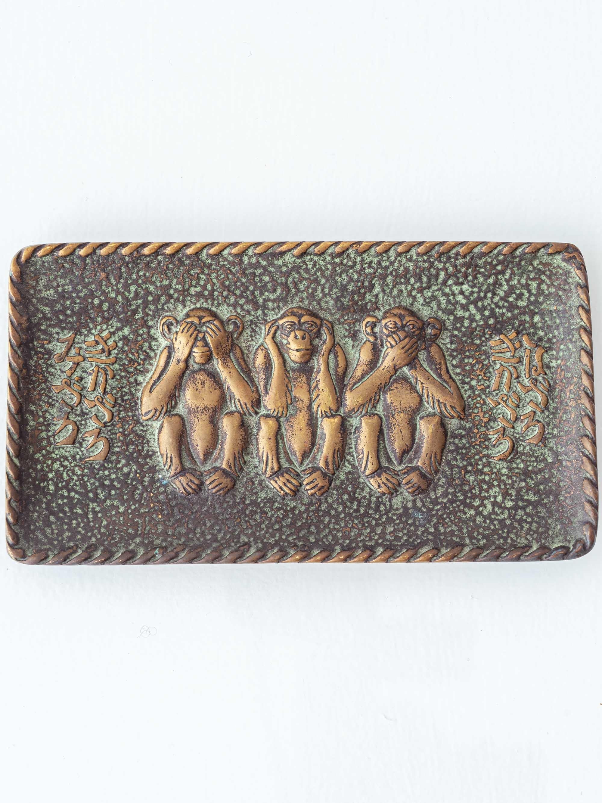 Max Le Verrier Art Deco bronze vide-poche, “Le secret du bonheur,” with verdigris patina and relief of the Three Wise Monkeys. The rectangular tray presents a finely modeled trio—see no evil, hear no evil, speak no evil—on a textured,