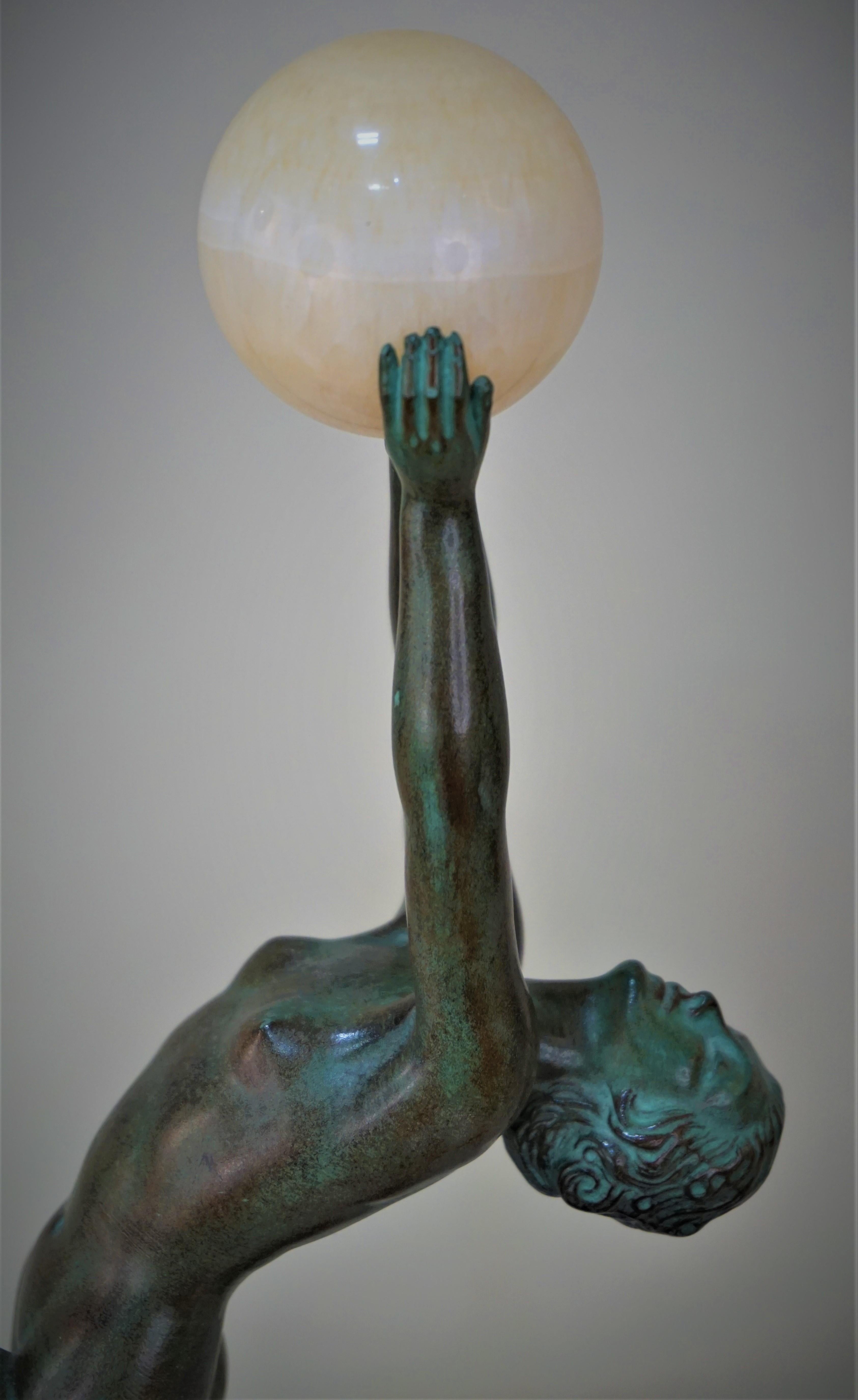 Sculpture in green/brown patinated of a nude dancer dancing with a ball is designed by Max Le Verrier.