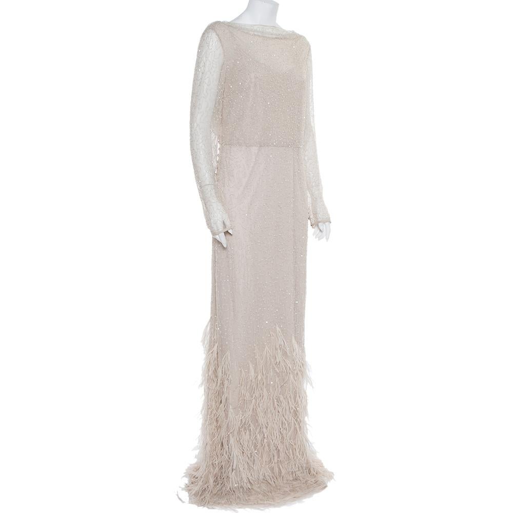 Have a memorable evening with Max Mara! The Couture dress in tulle has embellishments of sequins and beads all over, a draped back, and feathers that enhance the hemline. It has a matching lining and side button closure.

Includes: Brand tag with