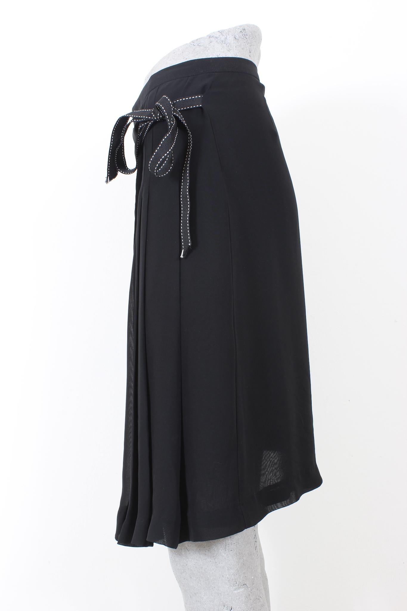 The Max Mara 90s black vintage pleated skirt model wraparound with a chic bow at the waist for a timeless look. Crafted in luxurious black viscose, this skirt is perfect for a timeless look from day to night.

Size: S

Waist: 33 cm
Lenght: 55 cm