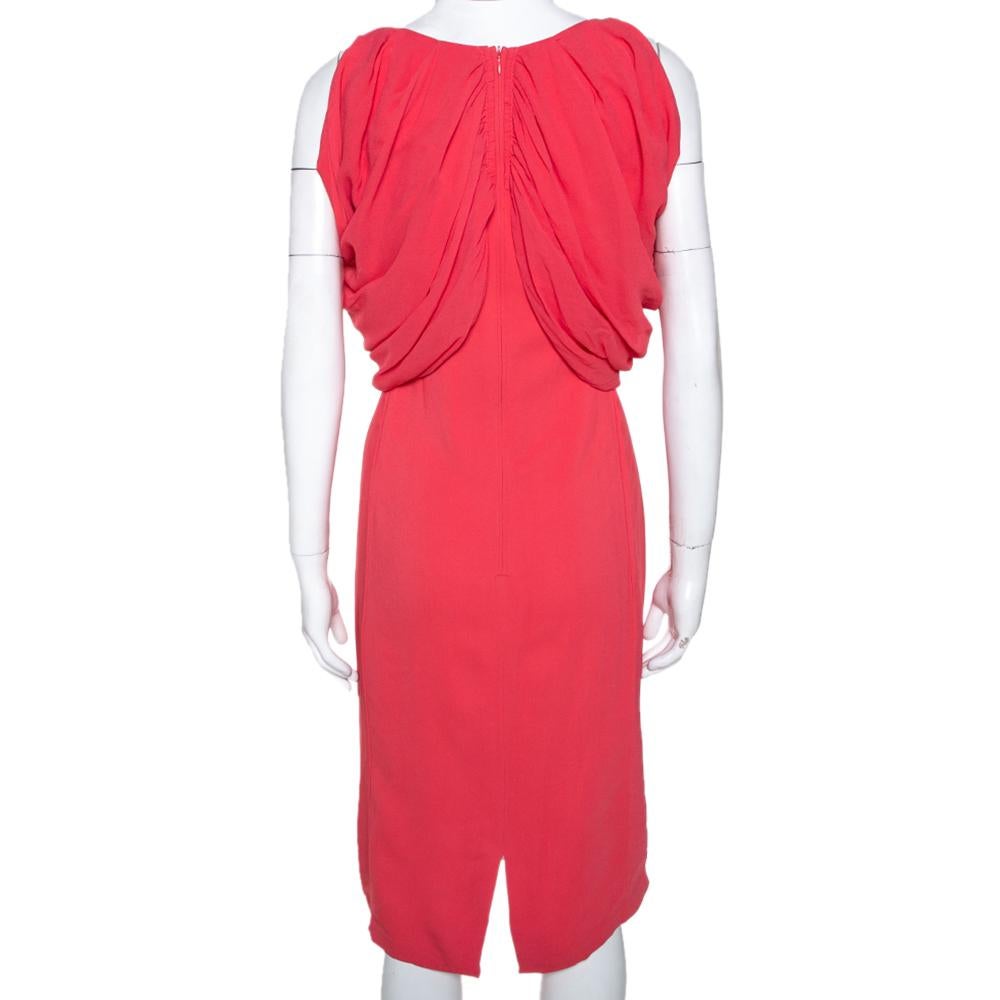 This sheath dress hails from the house of Max Mara. Crafted from quality fabrics, it comes with a pure silk lining. It carries a coral pink hue. This sleeveless dress is a luxurious pick for special occasions. It has a draped style, zip closure,