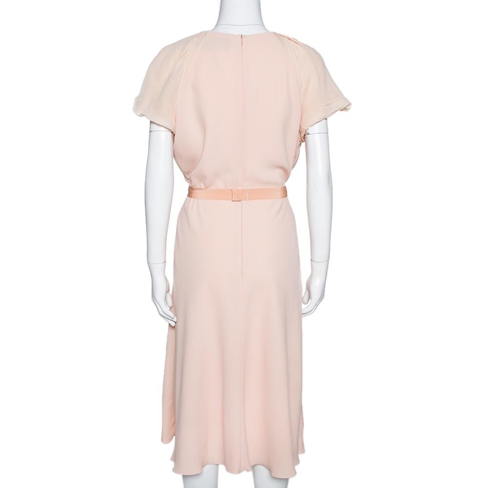 This Max Mara dress stands out beautifully. Style this elegant piece with dainty accessories for a unique and attractive look. Designed with a subtle light orange shade all over and a feminine midi silhouette, the dress features short sleeves and