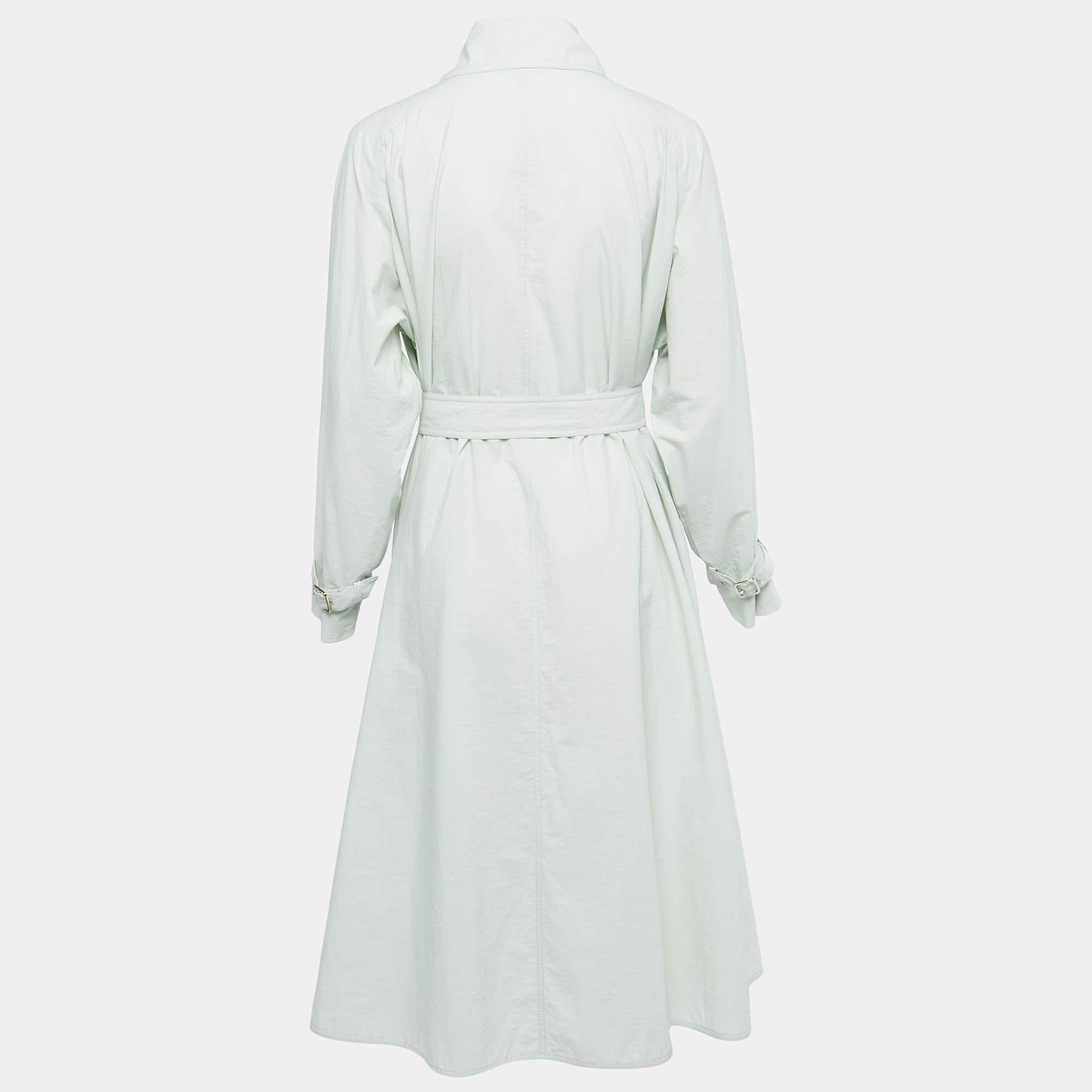 The Max Mara trench coat is a stylish and sophisticated outerwear piece. Crafted from high-quality cotton, it features a double-breasted design with a belted waist, adding a flattering silhouette. The fresh mint green color adds a touch of elegance