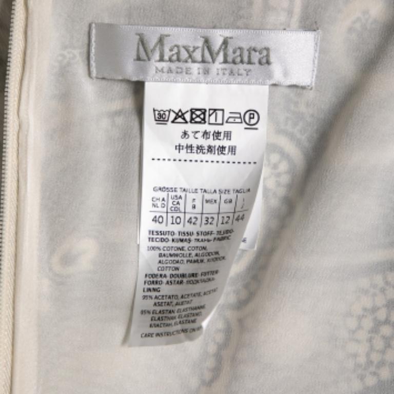 Questo abito della Maison Max Mara emana charme e raffinatezza in egual misura. È realizzata in tessuto di cotone monocromatico con stampa paisley e presenta dettagli drappeggiati. È caratterizzato da una scollatura a V, uno stile senza maniche e