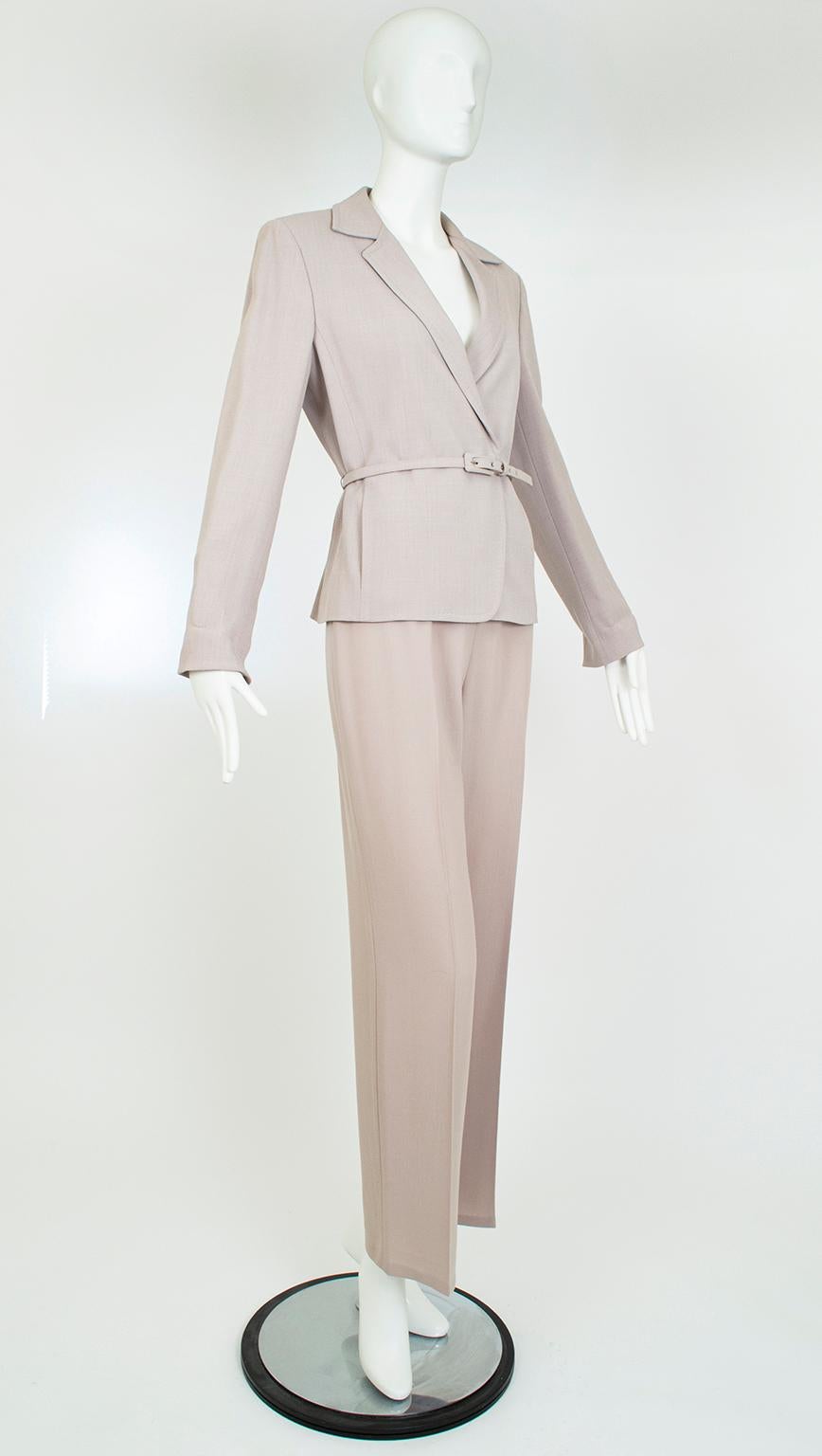 Brimming with understated European luxury, this tonal taupe suit strikes just the right balance between strength and femininity. The softly flowing trousers complement the gentle curves of the wrapping jacket, whose wide shoulders are gracefully