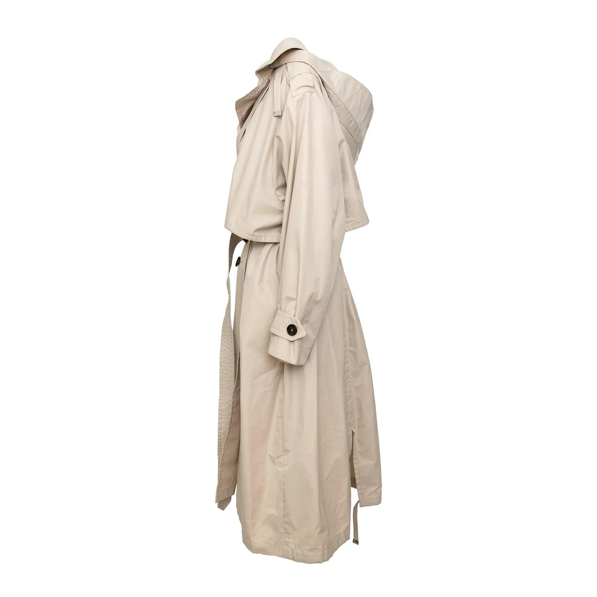 L'iconico trench The Cube di Max Mara in cotone con chiusura a doppio petto con bottoni, polsini e vita con cintura e un orlo sottilmente svasato che modella la silhouette.
 Osservazioni: Viene fornito con il cartellino. 
 Materiale: 100% cotone 
