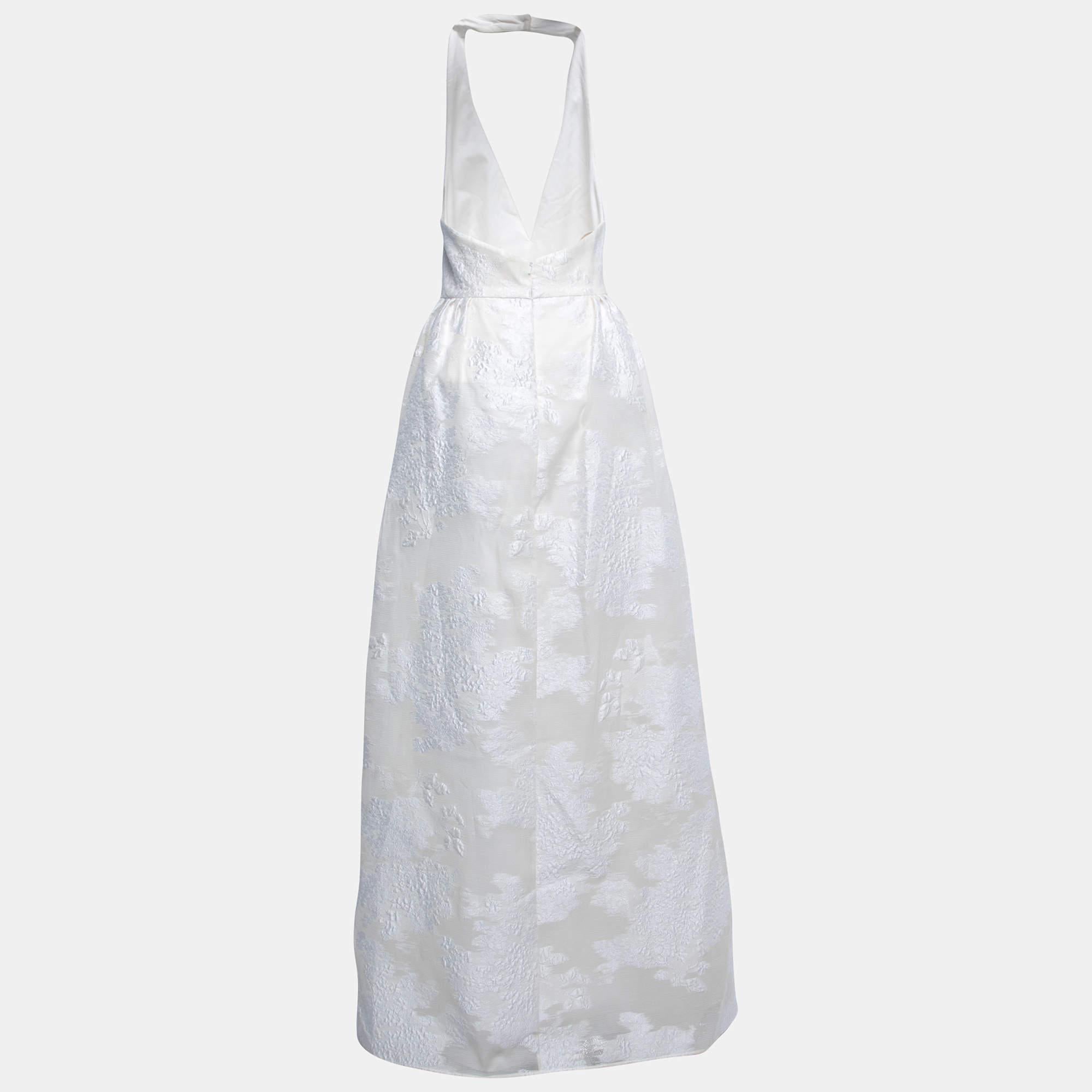 The Max Mara Ermione wedding dress is an exquisite choice for the modern bride. Crafted with meticulous attention to detail, this stunning dress features a halter neck silhouette and a shimmering white lurex jacquard fabric that adds a touch of