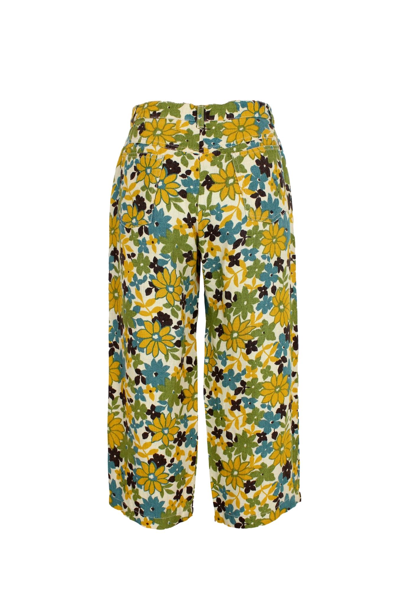 These are vintage 2000s Capri trousers from Max Mara. The trousers feature a beautiful floral pattern in shades of yellow, blue, and beige, adding a touch of elegance to your outfit. They are made of high-quality linen, which is perfect for warm