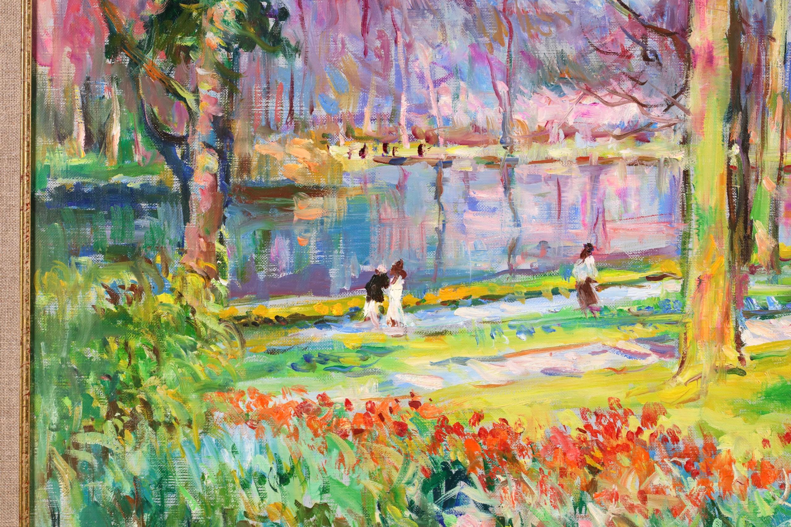 Figura post impressionista firmata e titolata in un olio paesaggistico del 1980 circa del pittore francese Max Michel Agostini. L'opera raffigura i frequentatori del parco su un sentiero accanto a un lago in una soleggiata giornata di primavera. In