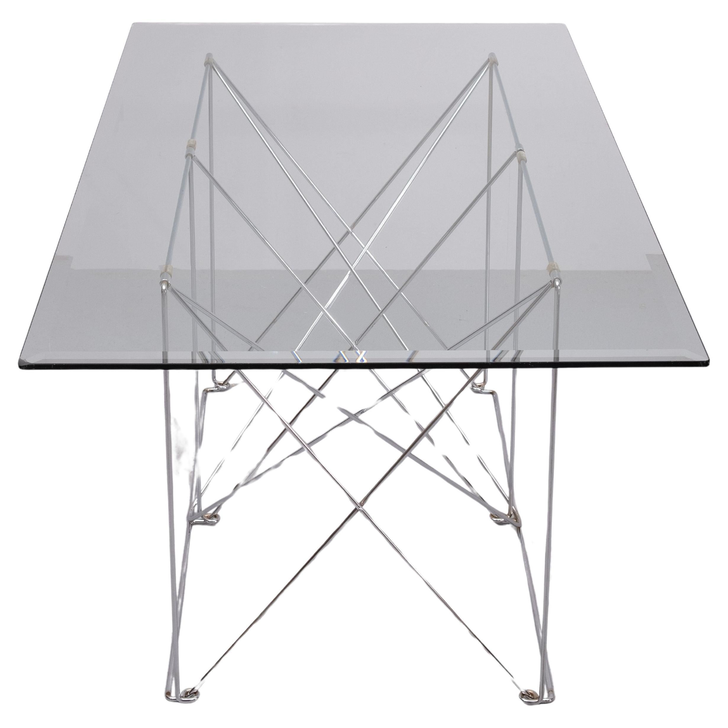 Table de salle à manger minimaliste pliable créée par le designer français Max Sauze. Max Sauze est surtout connu pour ses lampes en aluminium. Il aime beaucoup travailler avec des meubles où le minimalisme et le métal sont à l'honneur. Cette
