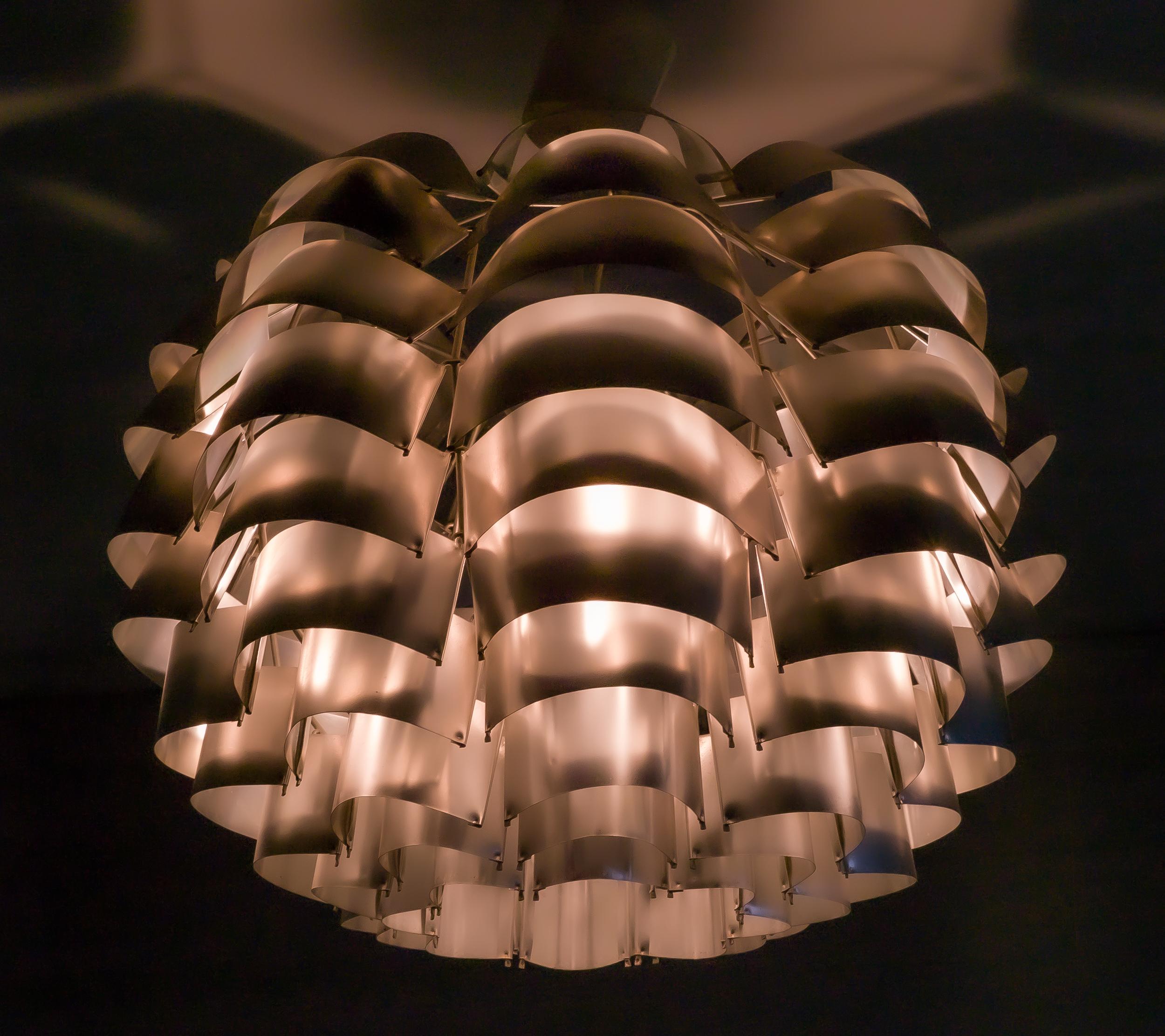 La araña Orion de Max Sauze es una pieza de diseño de iluminación llamativa y elegante. Diseñada por Max Sauze, escultor, diseñador y arquitecto francés, la lámpara presenta un diseño único y moderno que es atrevido y sutil al mismo tiempo. La araña
