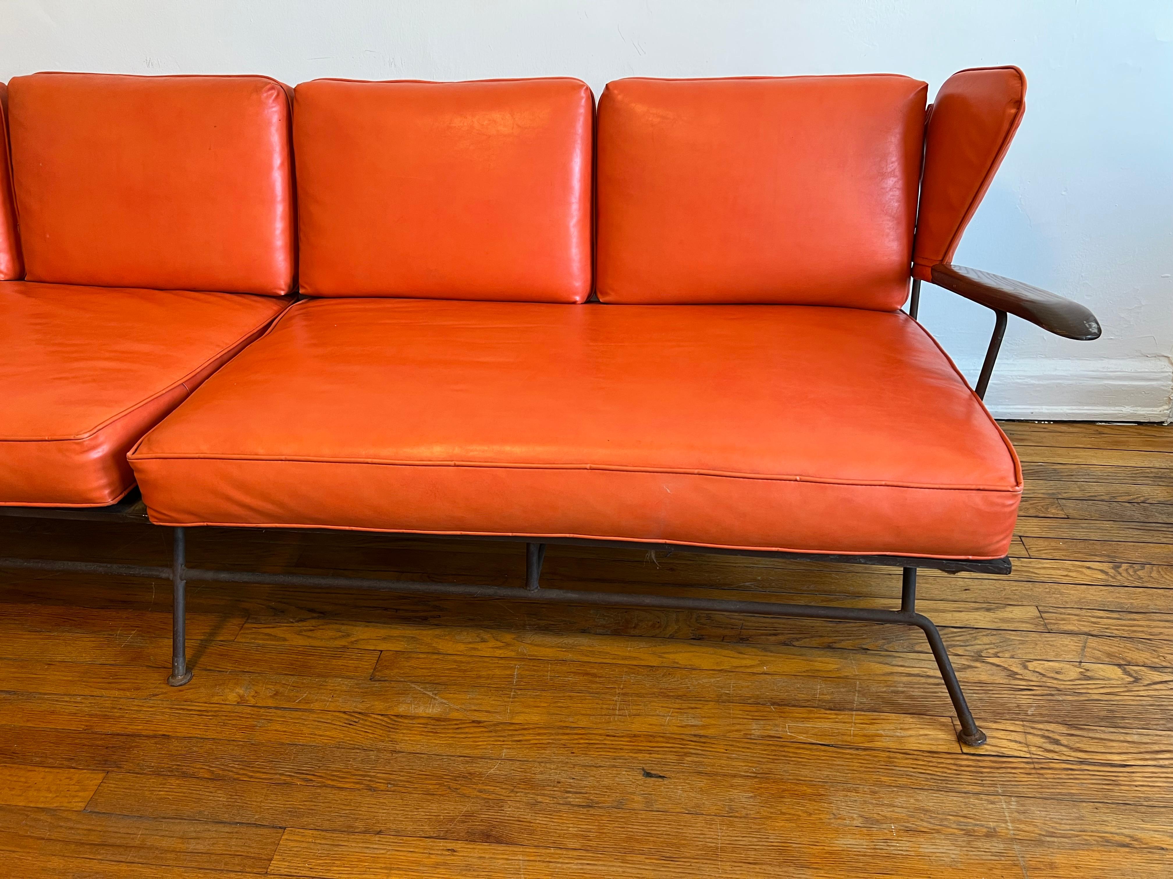 Very Rare sofa by North Carolina Blacksmith and furniture designer and maker Max Stout.

Sofa is in complete original condition with original cushions (foam) and the original Orange naugahyde fabric. There is one small cut/nick to the wing back
