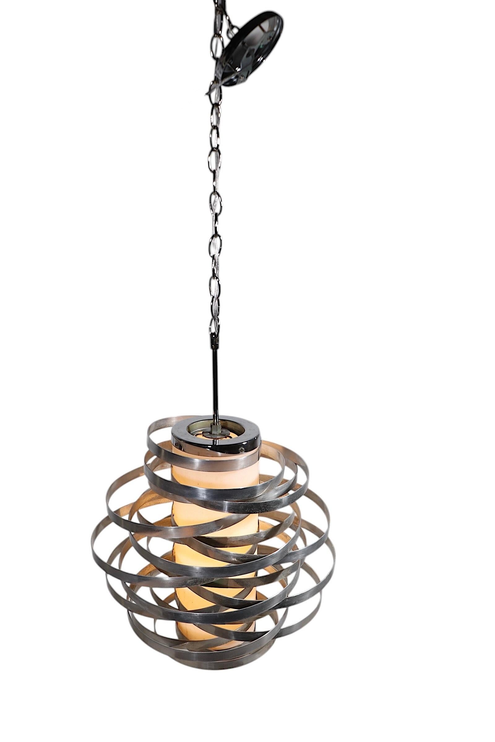 Icónica araña Cyclone diseñada por Max Suaze para Sciolari Lighting, fabricada en Italia  circa 1970's. La luminaria presenta bandas repetitivas de aluminio que rodean el cilindro central, fabricado con acrílico blanco translúcido.
 Este ejemplo