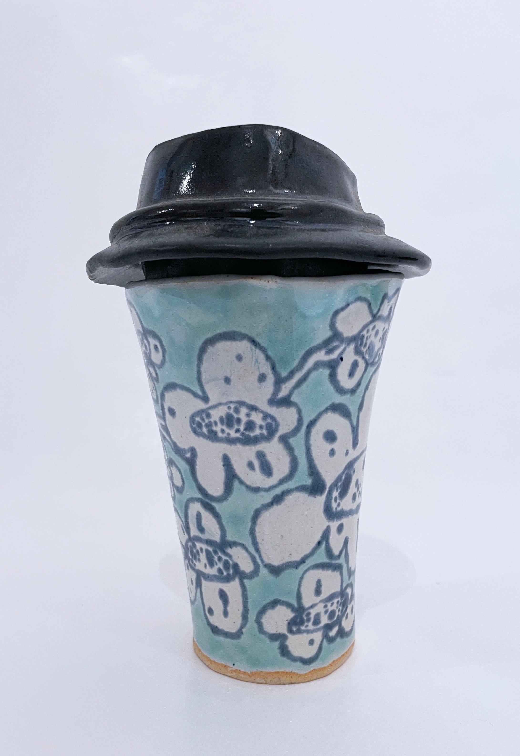 Blossom Cup (2022), glazed ceramic, clay tumbler with clay lid, coffee mug, floral pattern, aqua, cerulean, pale turquoise, white with black lid. Functional art object.

Hand glazed, hand built ceramic coffee cup inspired by to go or take out paper