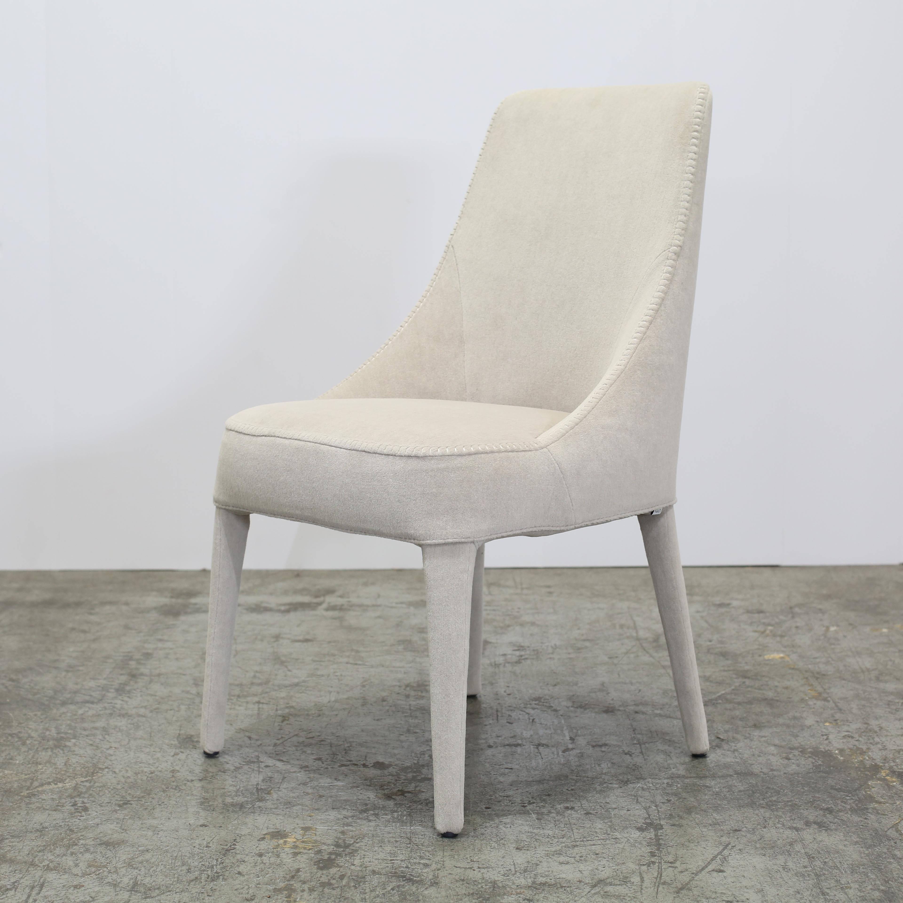 The Cream Velvet Febo Chair by Maxalto (set of six) offers an exquisite fusion of elegance and comfort. Deeply cushioned seats and backs are upholstered in sumptuous cream velvet, creating a soft, inviting feel. Its subtly curved form rests on