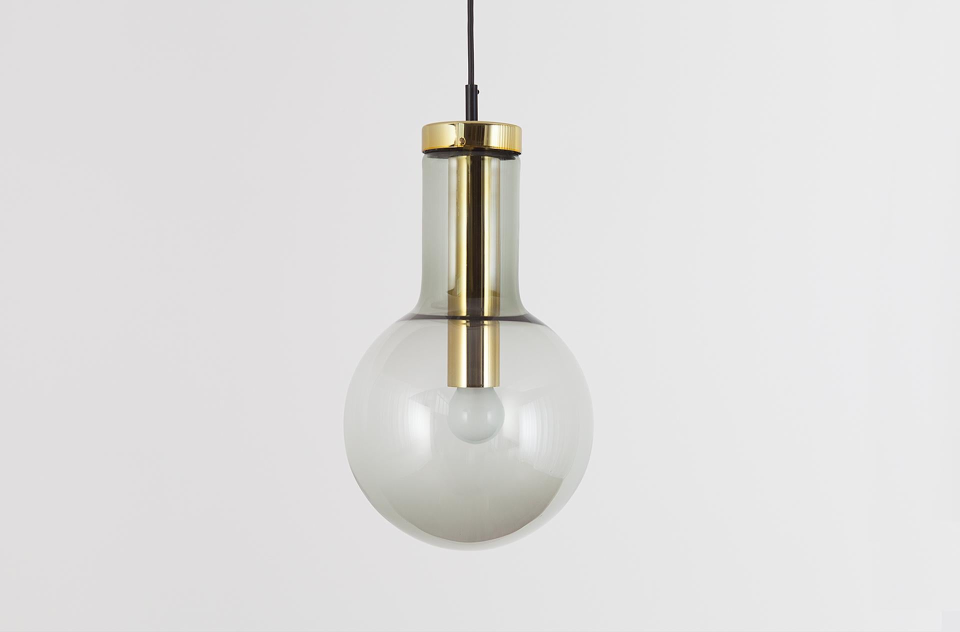 Large size version. Light smoked glass with brass colored metal socket.
 
In the early 1960s, RAAK produced this extraordinary pendant in 3 different sizes, named according to the logic of their striking design. The shape of the pendant -familiar