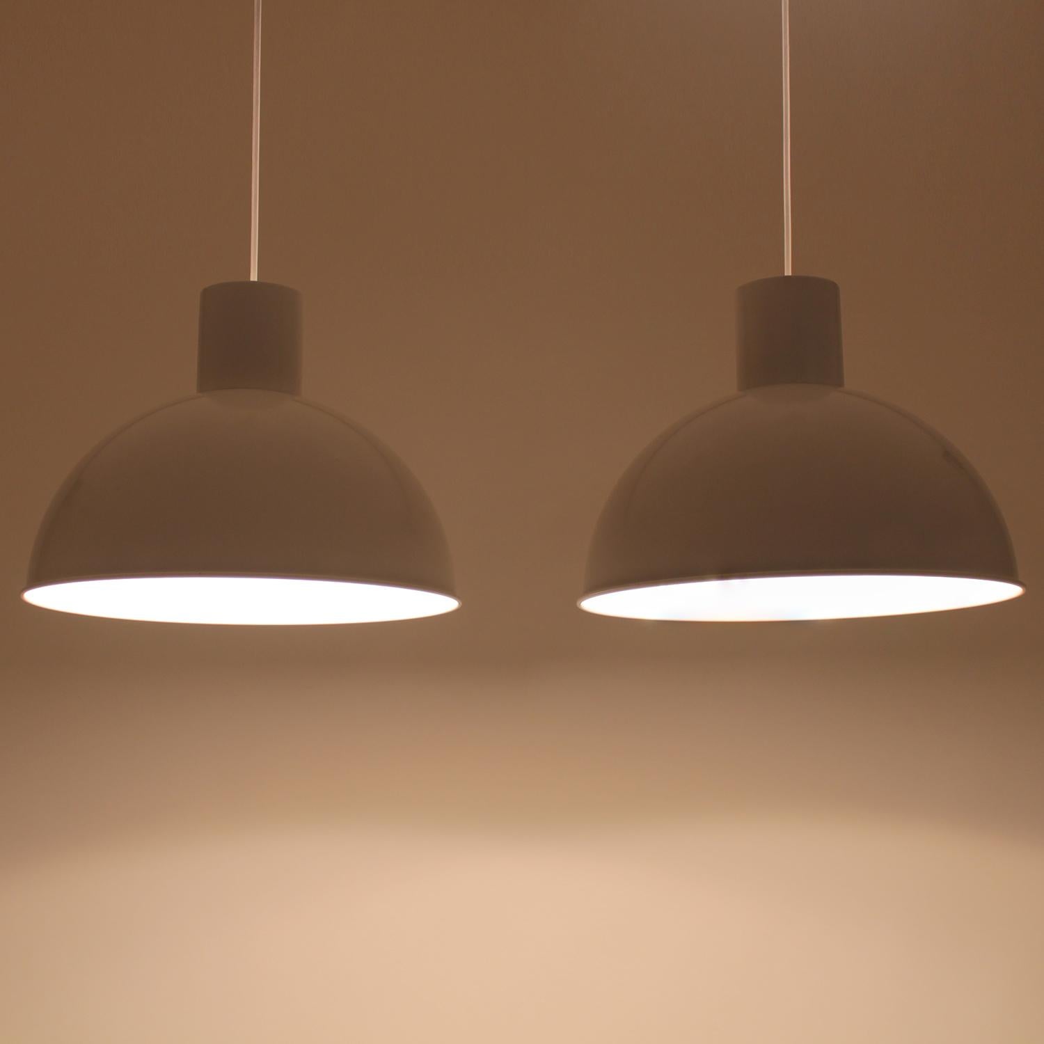 Maxi Bunker (Pair), large white pendant pair by Jo Hammerborg in 1974 and produced by Fog & Mørup - stylish workshop pendants in good vintage condition.

Up for sale here is a pair of white metal pendants with large dome shaped shades and cylinder