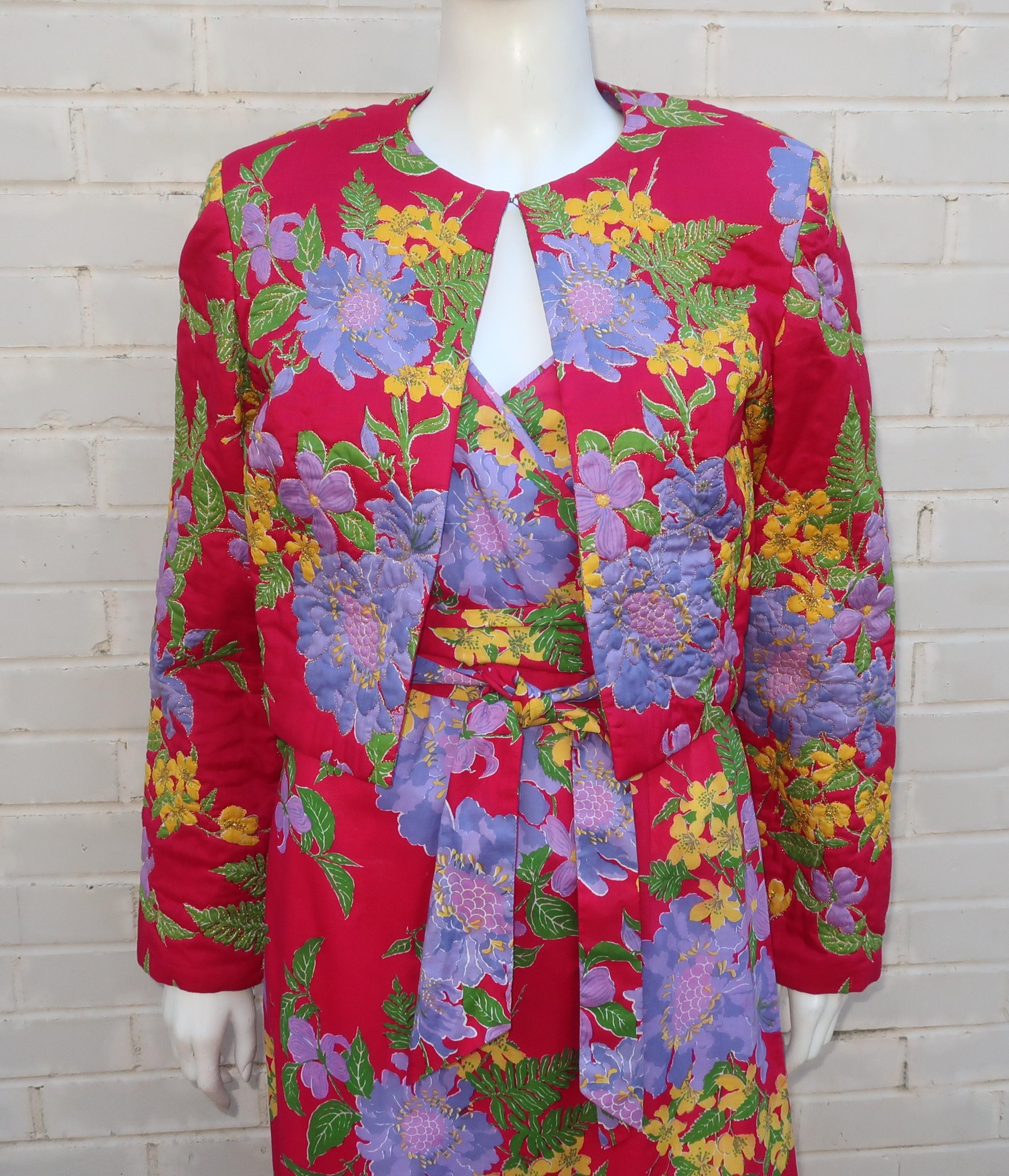 C.1970 cotton sun dress with a coordinating quilted bolero jacket and tie belt by Thai Lines of Bangkok.  Both pieces are in a tropical hand screened floral print in vibrant shades of magenta, purple, yellow and green.  The dress zips and hooks at