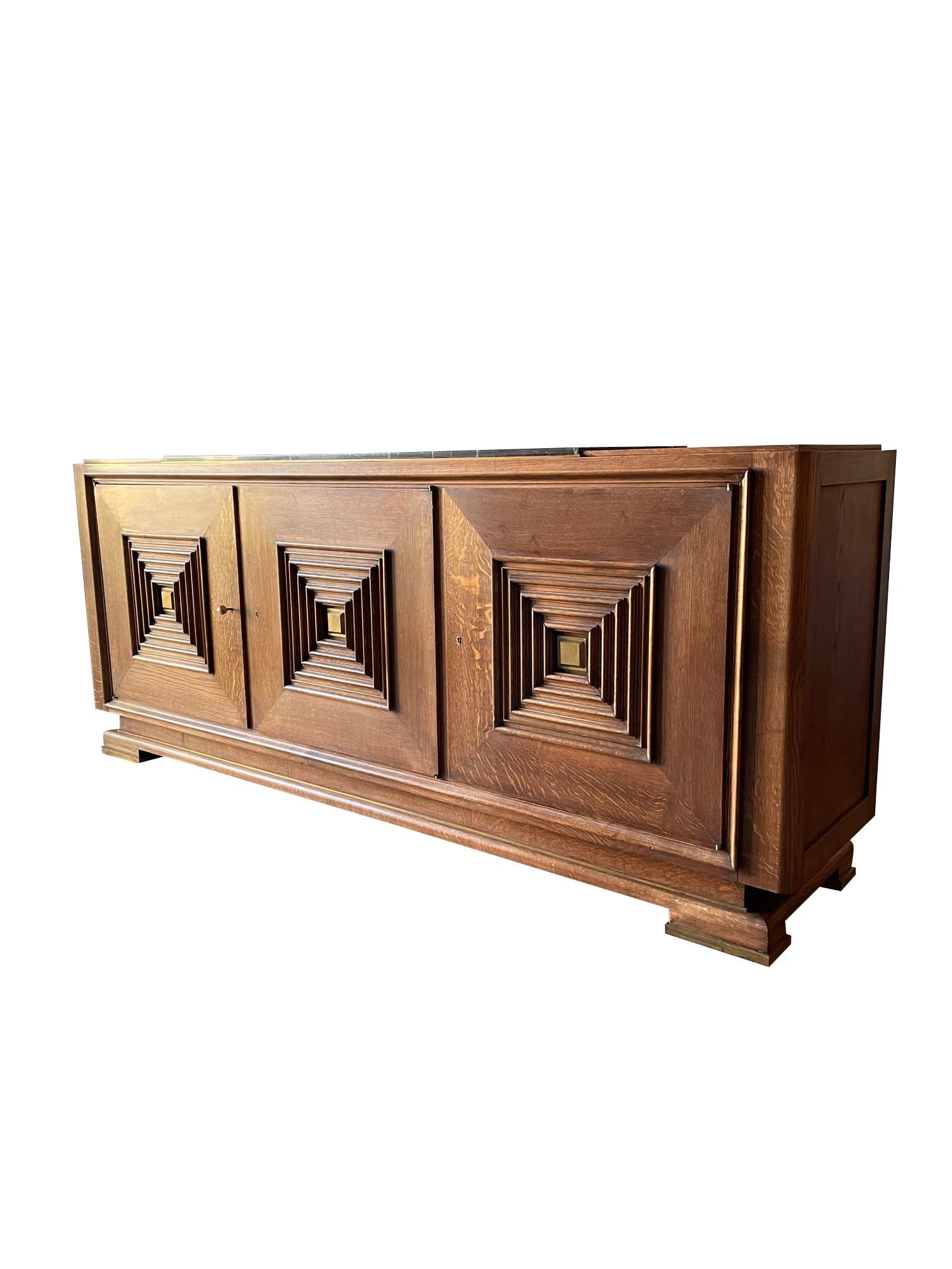 1960's French Maxime Old credenza.
Oak with center marble piece on top.
Three doors with signature concentric square panel design.
Six inner shelves and one inner drawer.
Decorative brass details.
Recently refinished.
ARRIVING TBD.