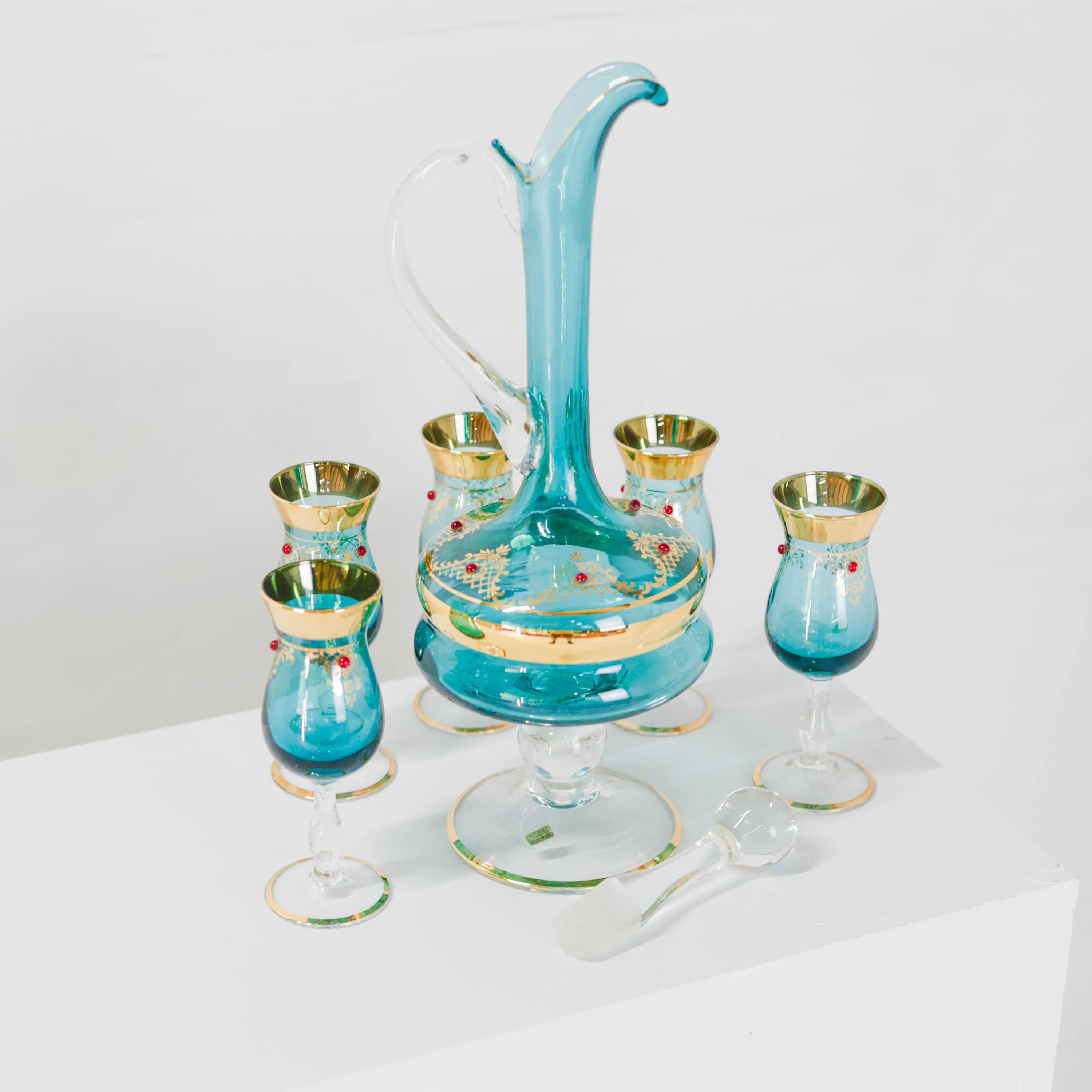 This never-used Midcentury (circa 1960s) handblown Venetian glass decanter and five cordial glass set is a maximalist's dream.

The azure blue glass decanter has been gilded in 22k yellow gold around the belly of the decanter, along the elegantly