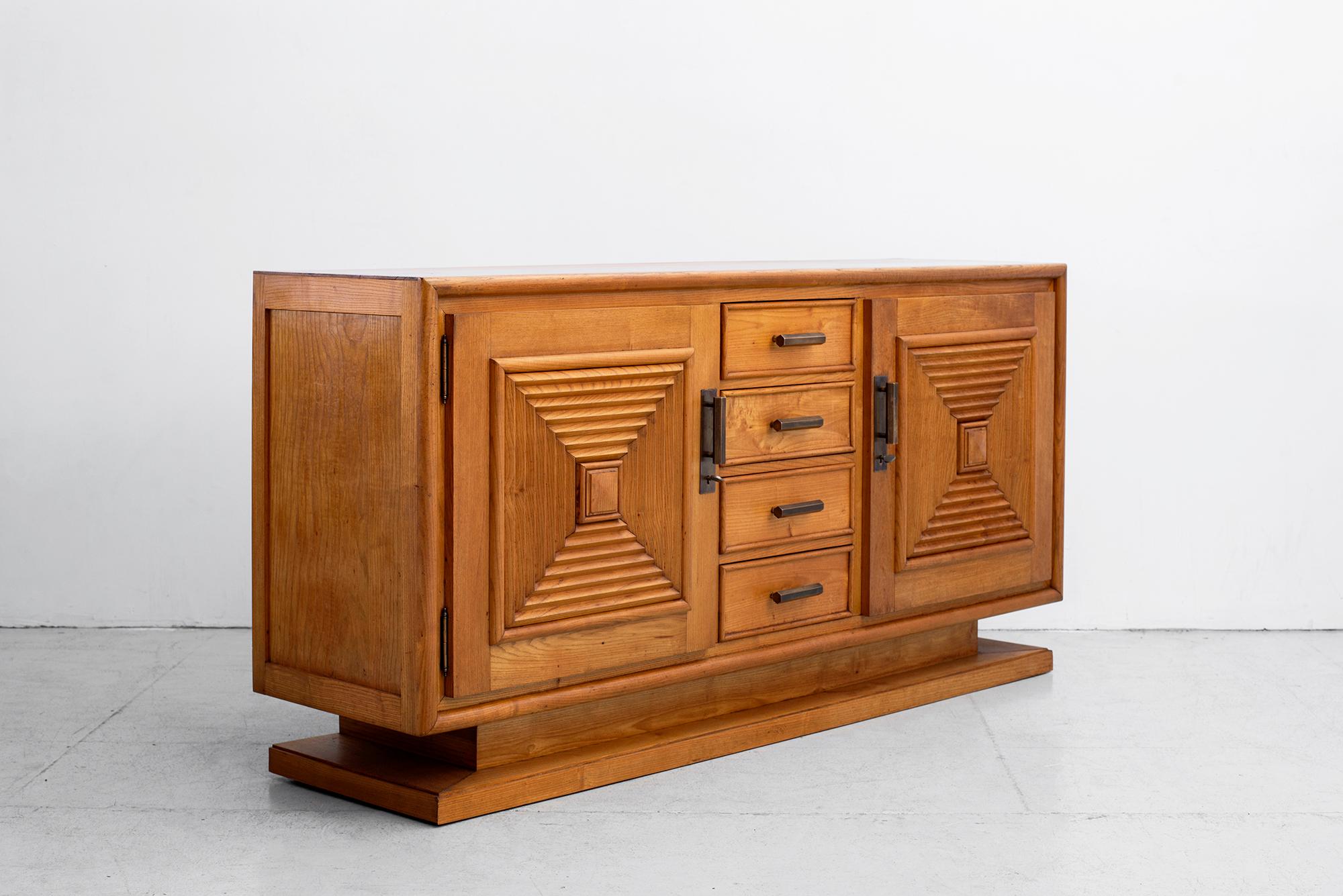 Fantastic Art Deco cabinet attributed to Maxime Old. 
French oak with wonderful patina. 
Four central draws flanked by carved cabinet doors revealing shelves on each side. 
Incredible piece! 
  