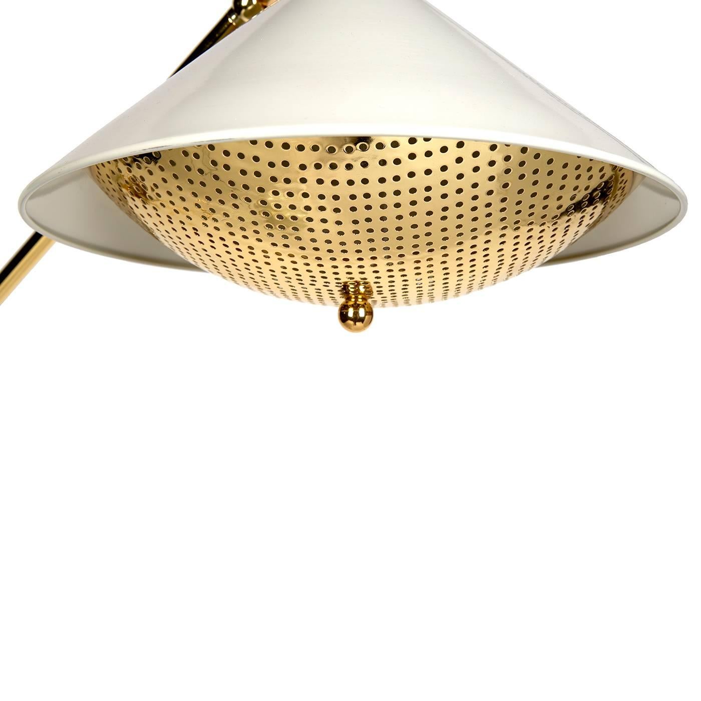Mad Men Meets Holly Golightly. A slim, brass stem with an antique white lacquered cone base, matching shade, and signature arrow sabot. Complete with a perforated brass diffuser, our Maxime task floor lamp casts a soft golden glow. Pair with your