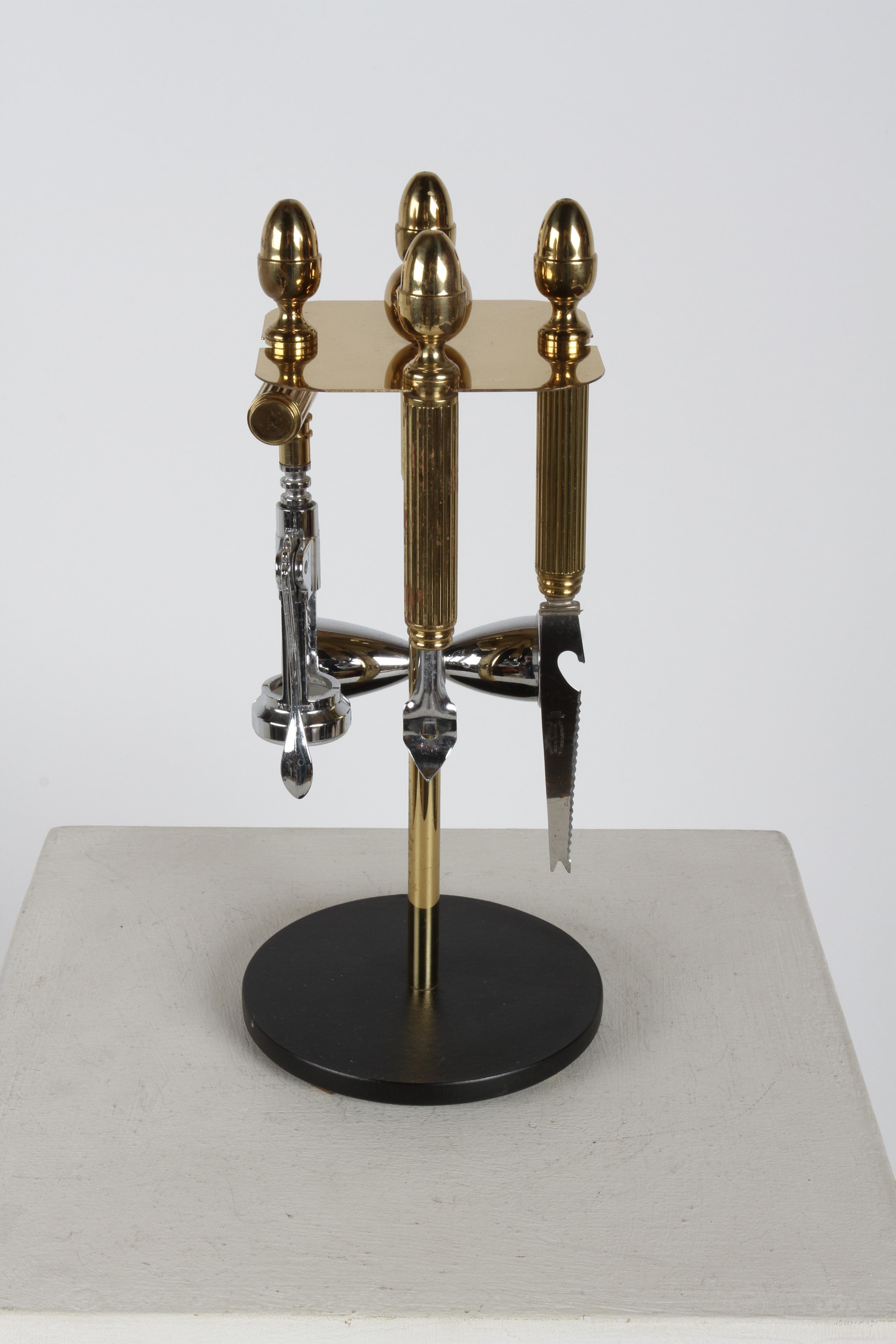 A Handsome, substantial and very well-made 4 - piece Mid-Century, Regency style brass acrorn topped set of barware or bartender tools on a circular stand by Maxwell Phillip. This set includes hourglass-shaped measuring device, aka as a jigger or