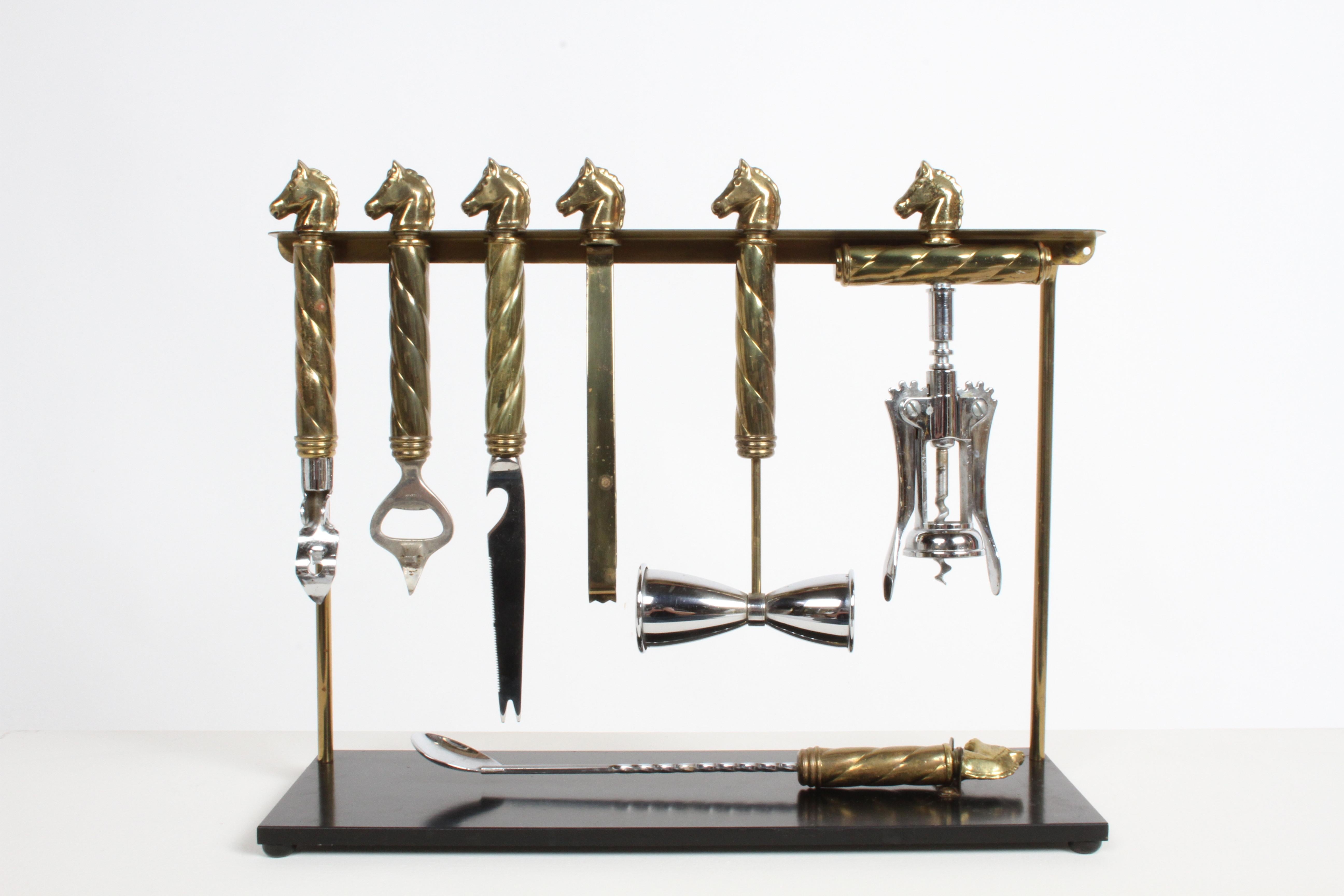 A Handsome, substantial and very well-made 7- piece Mid-Century equestrian theme, Regency brass horse head set of barware or bartender tools on a stand by Maxwell Phillips. This set includes hourglass-shaped measuring device, aka as a jigger or shot