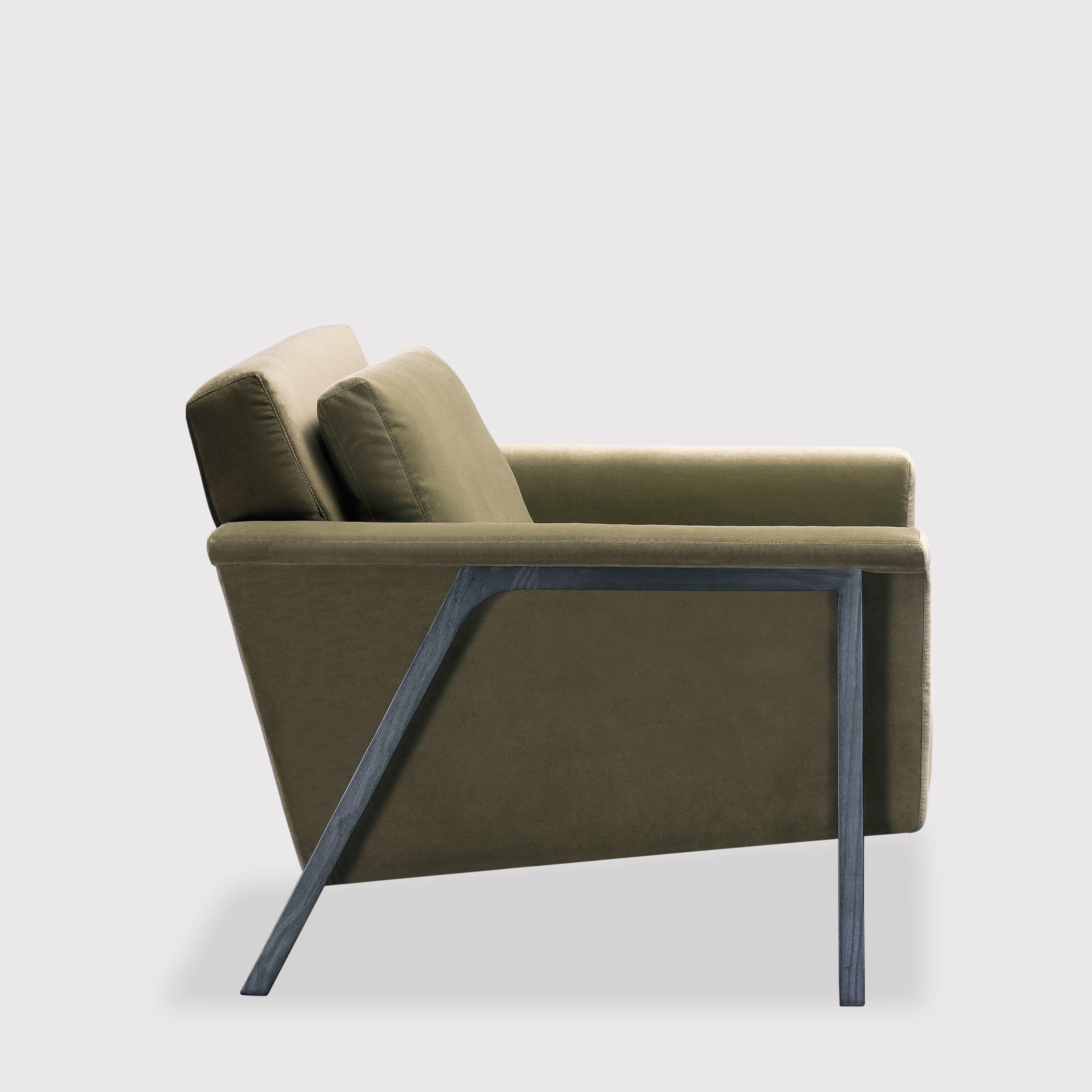 The Maxx armchair is a generously proportioned lounge chair taking its design cues from the Modernist style. The timber legs are positioned outside of the arm and reach from front to back in an inclined arch, effectively cradling the upholstered
