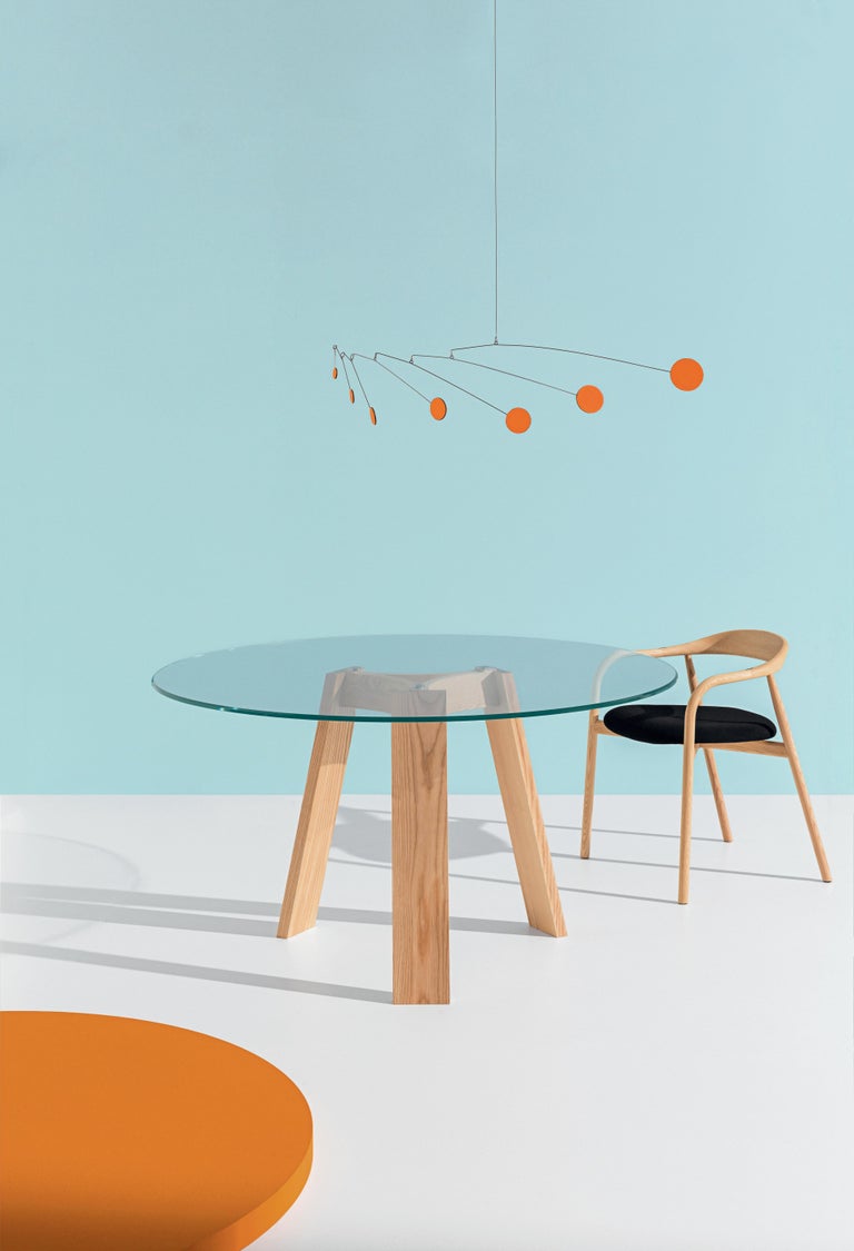 Dining table with natural ash legs with Ø59 inches tempered extra clear glass top.

Lars Beller’s MAYA table’s nod to ancient times goes far beyond its monumental, Mayan-reminiscent aesthetic. Joining together two of earth’s most elementary
