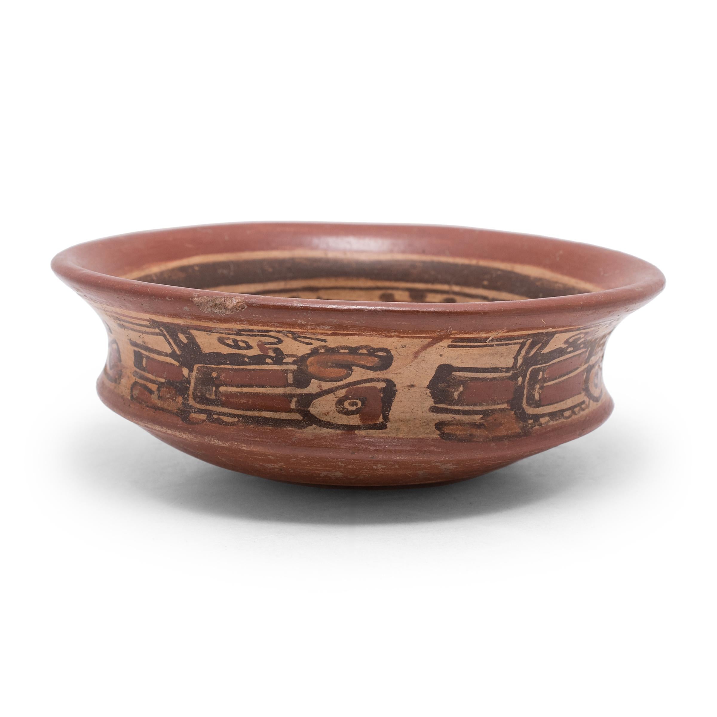 Exhibiting a rich patina, this petite Maya ceramic bowl dating back to c. 600-900 AD was crafted in the El Copador style. The El Copador style is a polychrome ceramic style often made in a cylindrical shape characterized by black and red