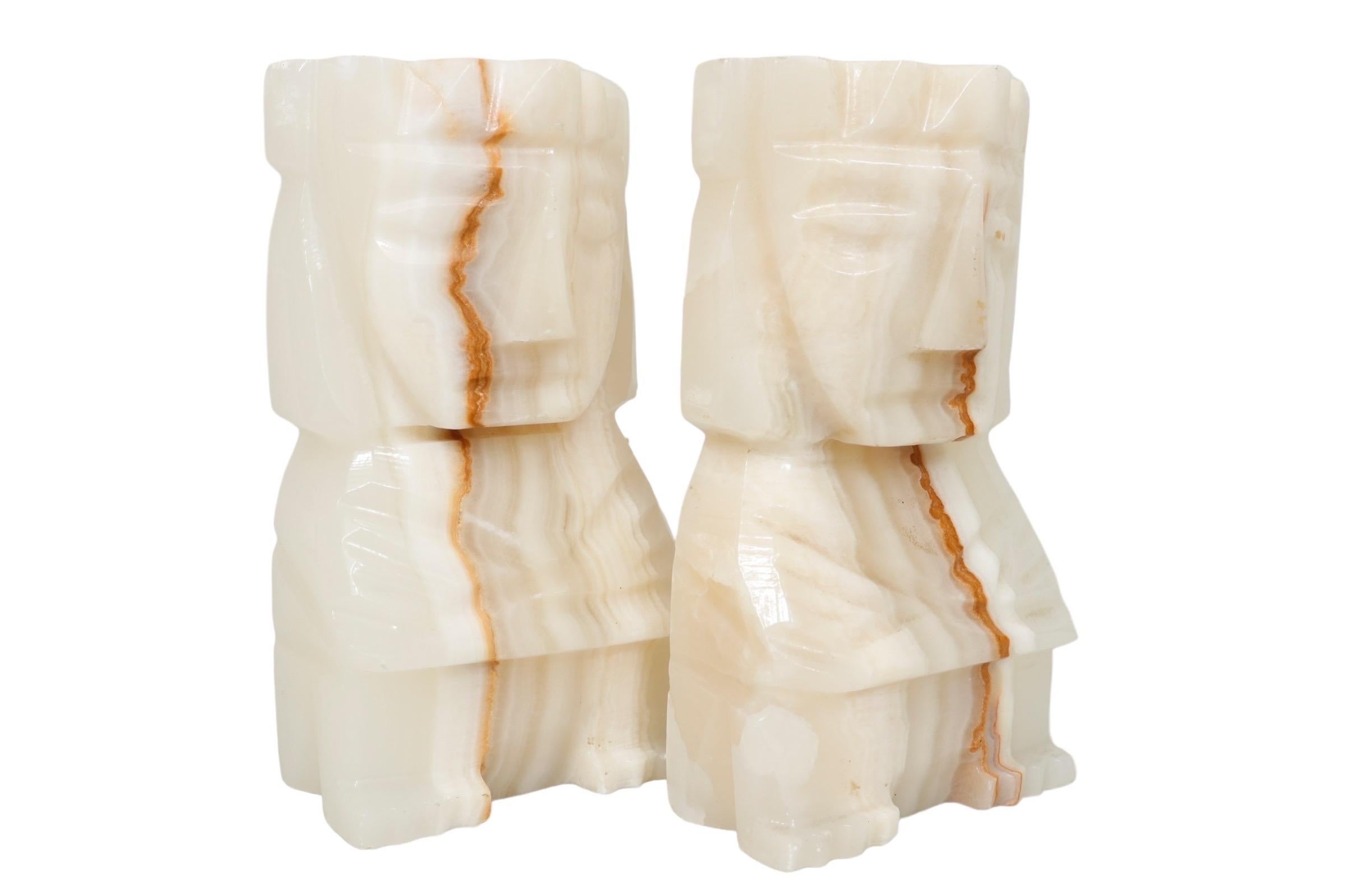A pair of agate bookends carved in the shape of Mayan figures in a seated position. Simple lines define the face topped with a crown, crossed arms and feet. The richly banded agate has a translucent quality. Dimensions per bookend.